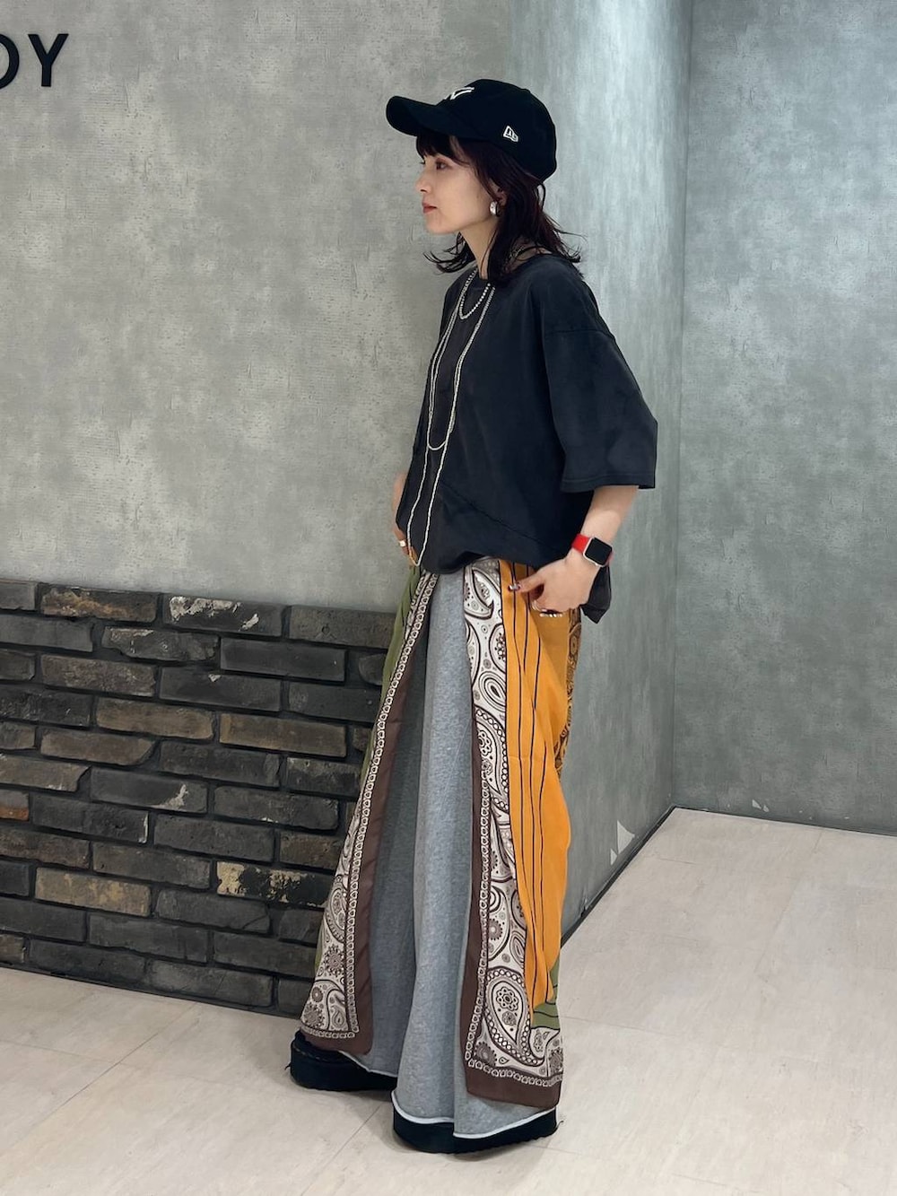 ブラック系のTシャツ/カットソー、グレー系のスウェットパンツ、ブラック系のキャップを着用したレディースの夏コーディネートの4枚目の写真