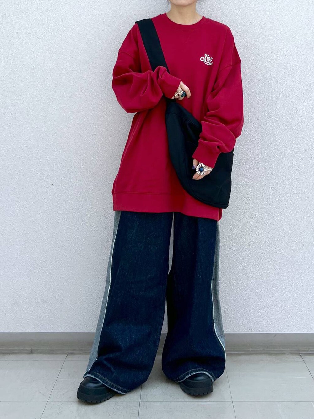 ブラック系のブーツ、ブラック系のショルダーバッグ、レッド系のスウェットを着用したレディースの秋コーディネートの6枚目の写真