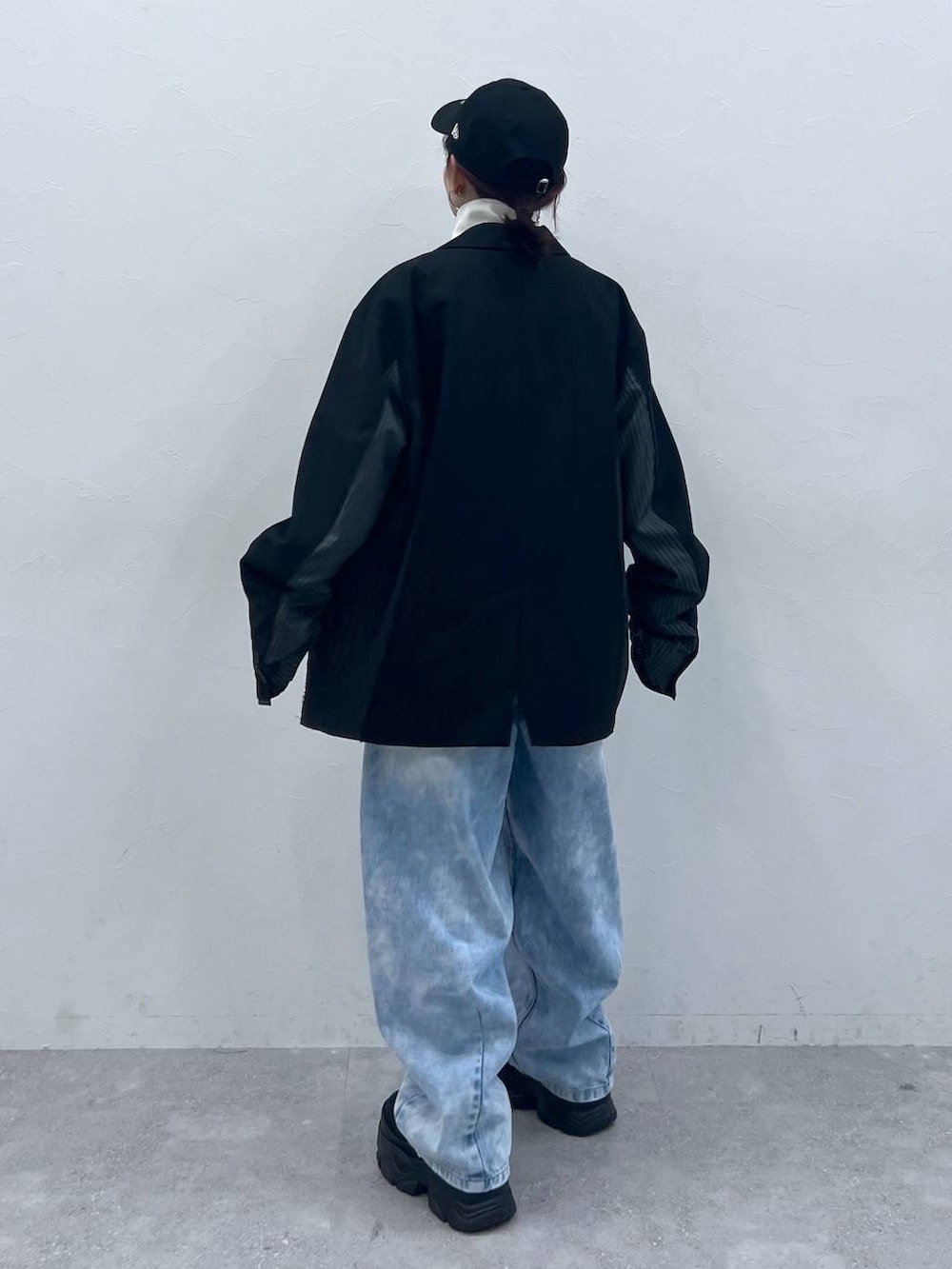 ブラック系のテーラードジャケット、ブラック系のスニーカー、ブラック系のジャージを着用したレディースの春コーディネートの4枚目の写真