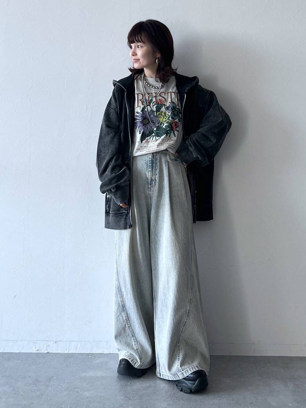 ブラック系のスニーカー、ブルー系のデニムパンツ、ベージュ系のTシャツ/カットソーを着用したレディースの秋コーディネートの6枚目の写真