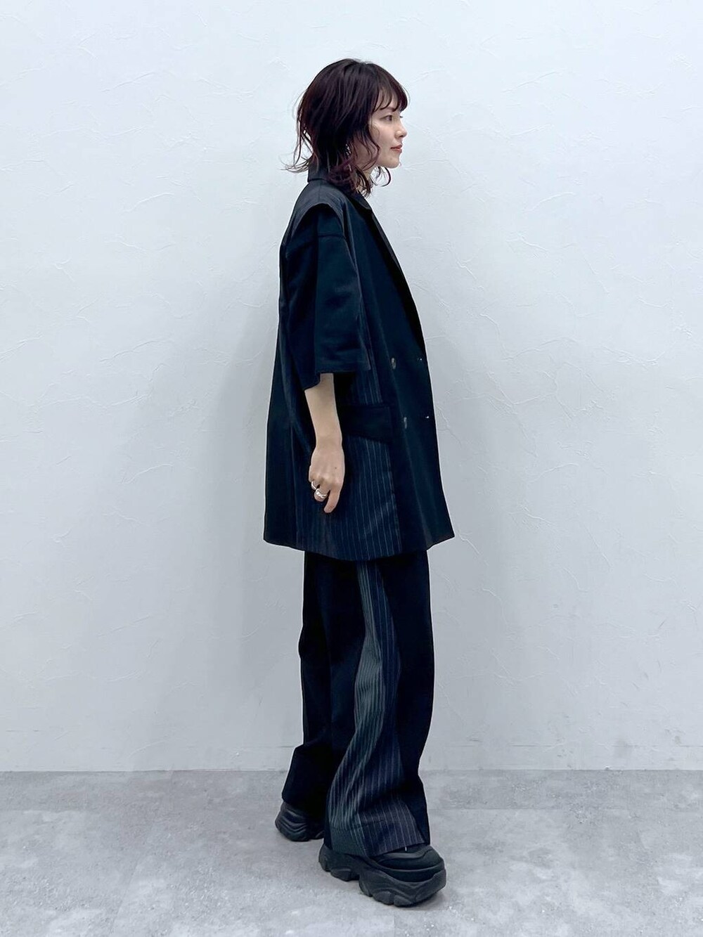 ブラック系のスラックス、ブラック系のTシャツ/カットソー、ブラック系のスニーカーを着用したレディースの春コーディネートの3枚目の写真