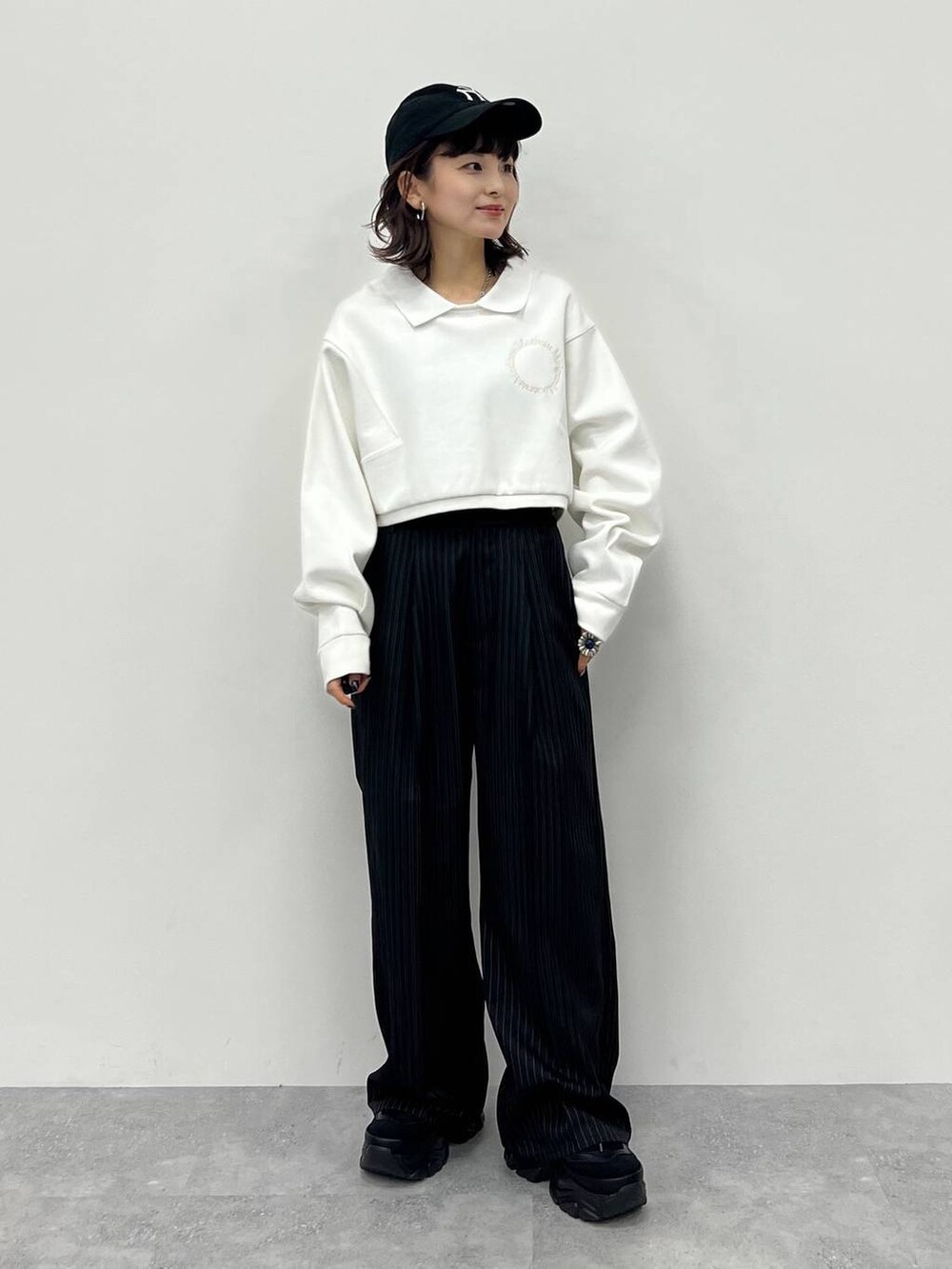 ブラック系のキャミソール、ブラック系のスラックス、ブラック系のスニーカーを着用したレディースの冬コーディネートの2枚目の写真