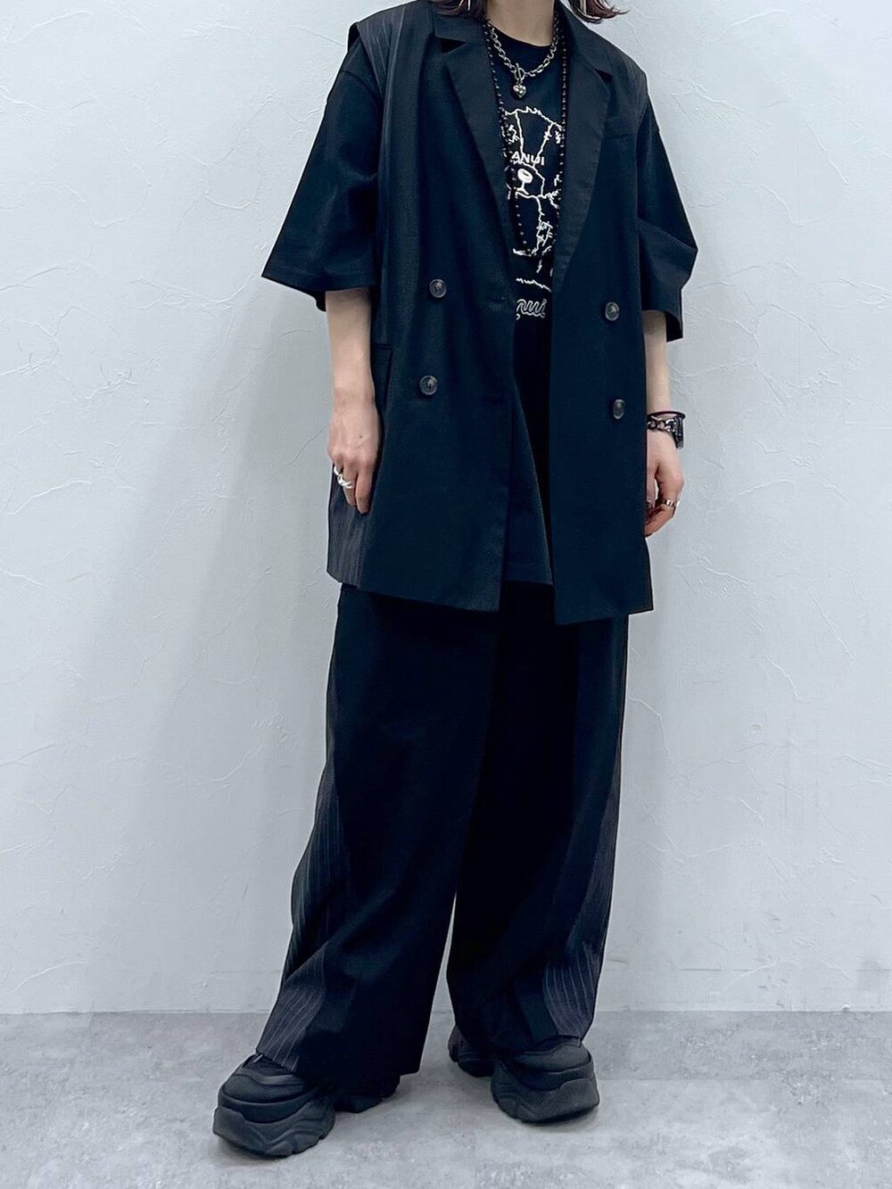 ブラック系のスラックス、ブラック系のTシャツ/カットソー、ブラック系のスニーカーを着用したレディースの春コーディネートの6枚目の写真