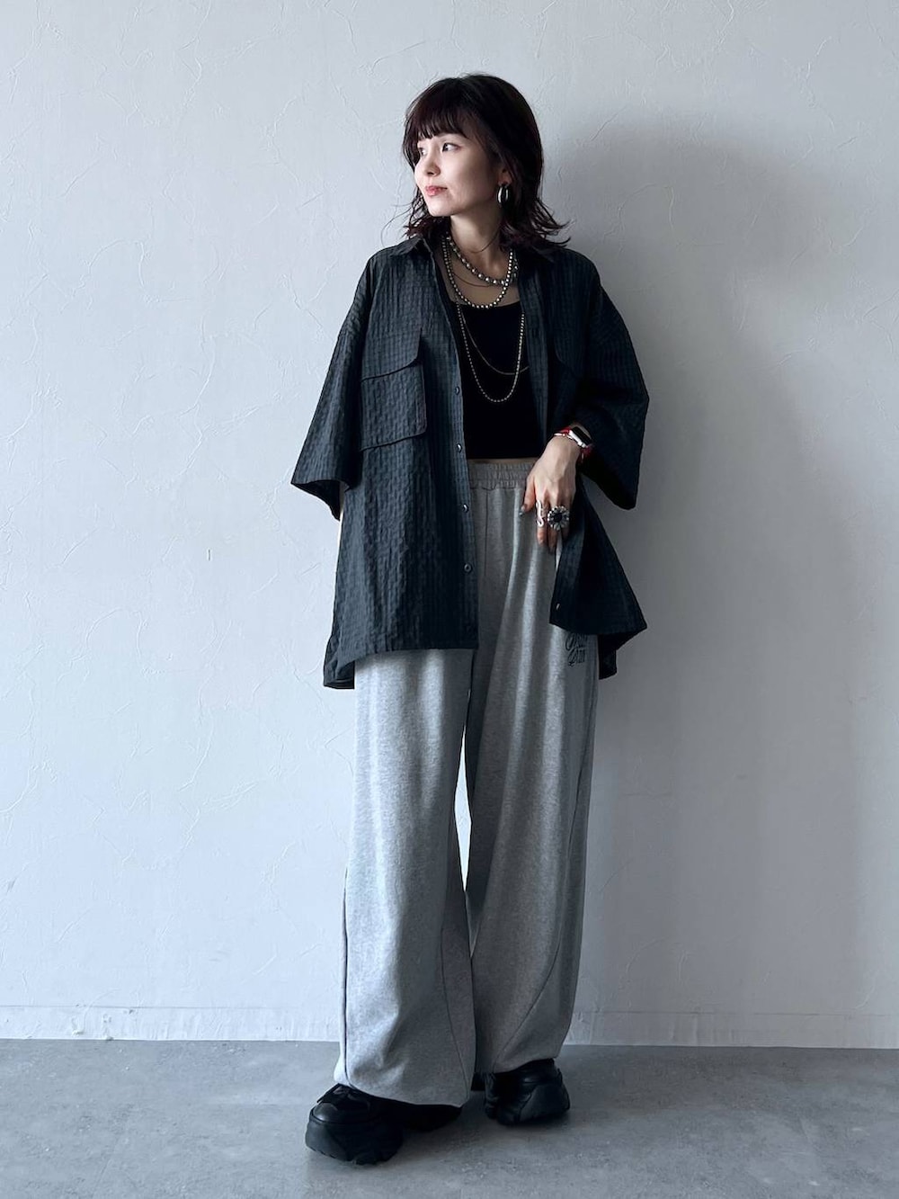 ブラック系のスニーカー、グレー系のスウェットパンツ、ブラック系のシャツ/ブラウスを着用したレディースの秋コーディネートの2枚目の写真