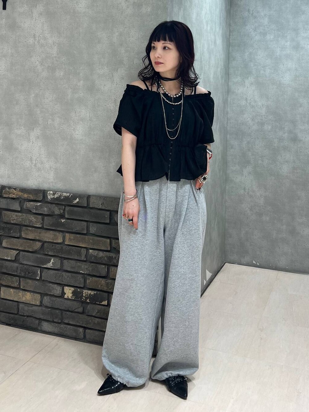 ブラック系のパンプス、ブラック系のシャツ/ブラウス、グレー系のスウェットパンツを着用したレディースの春コーディネートの6枚目の写真