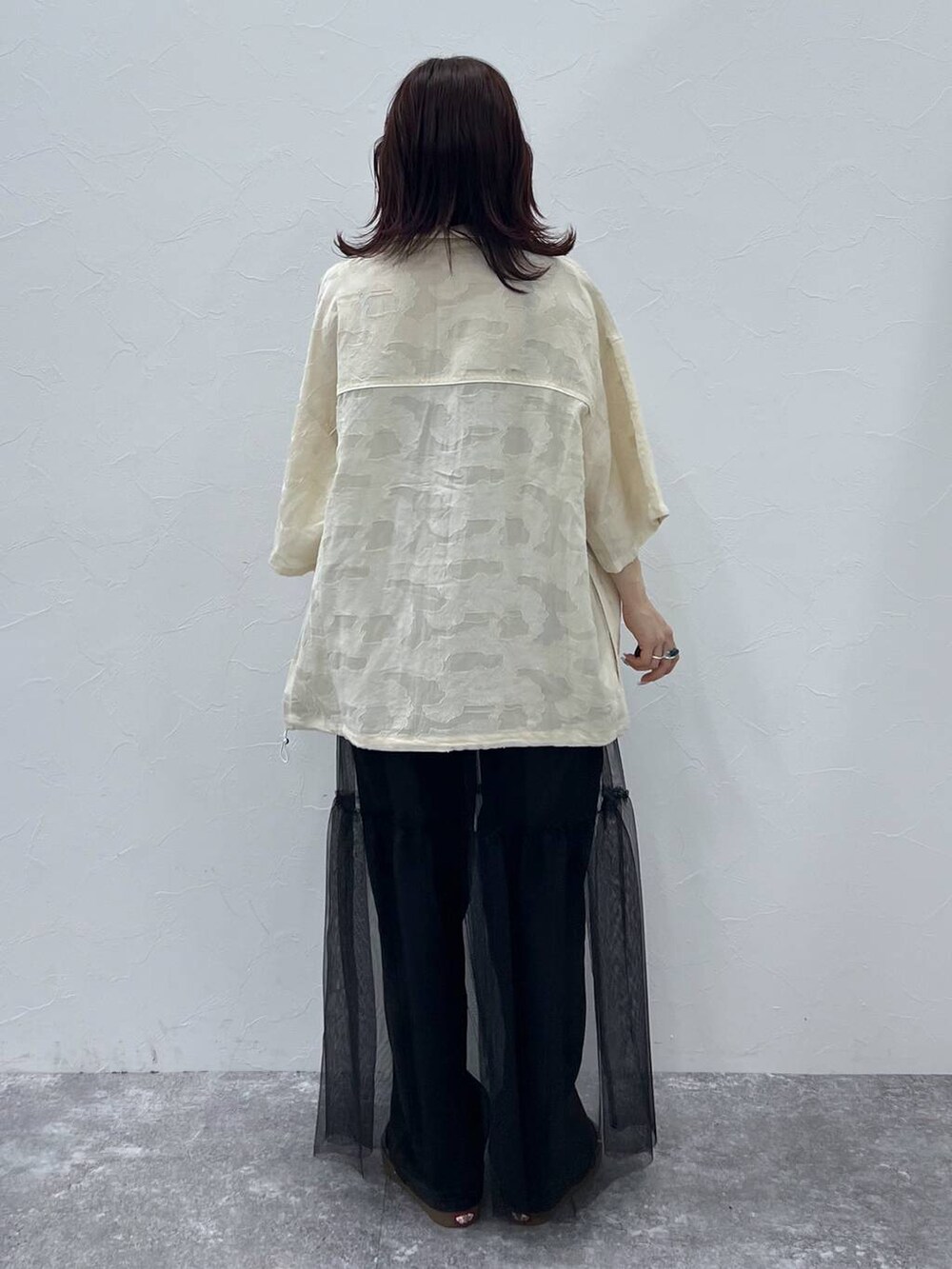 ブラック系のキャミソール、ブラック系のスカート、ブラック系のデニムパンツを着用したレディースの夏コーディネートの3枚目の写真