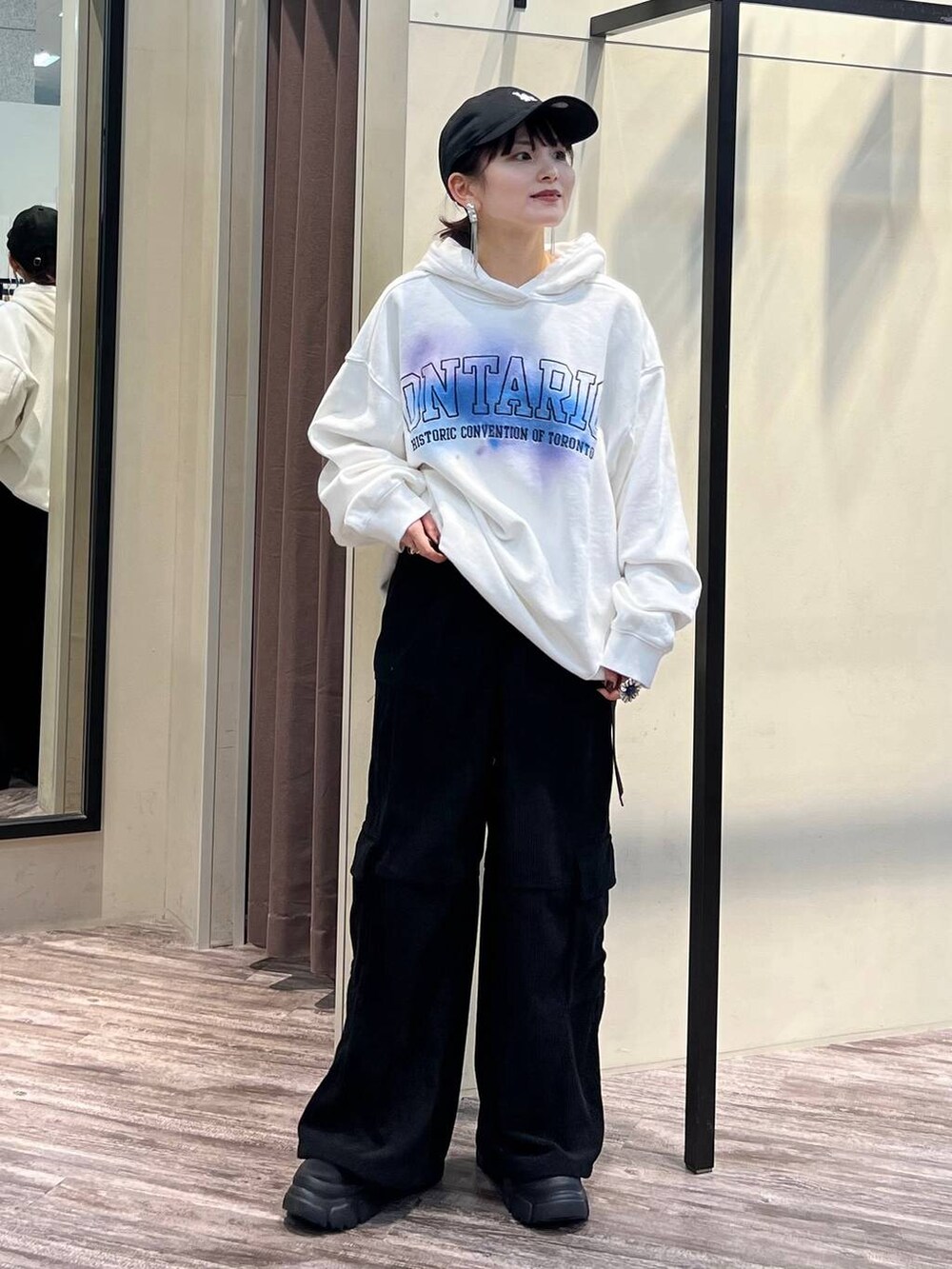 ブラック系のカーゴパンツ、ブラック系のブーツ、ホワイト系のパーカーを着用したレディースの冬コーディネートの8枚目の写真