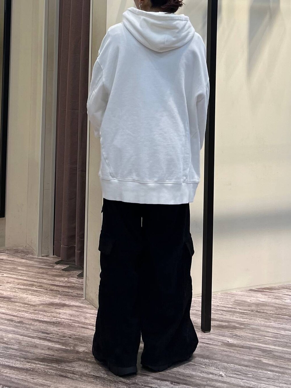 ブラック系のカーゴパンツ、ブラック系のブーツ、ホワイト系のパーカーを着用したレディースの冬コーディネートの6枚目の写真