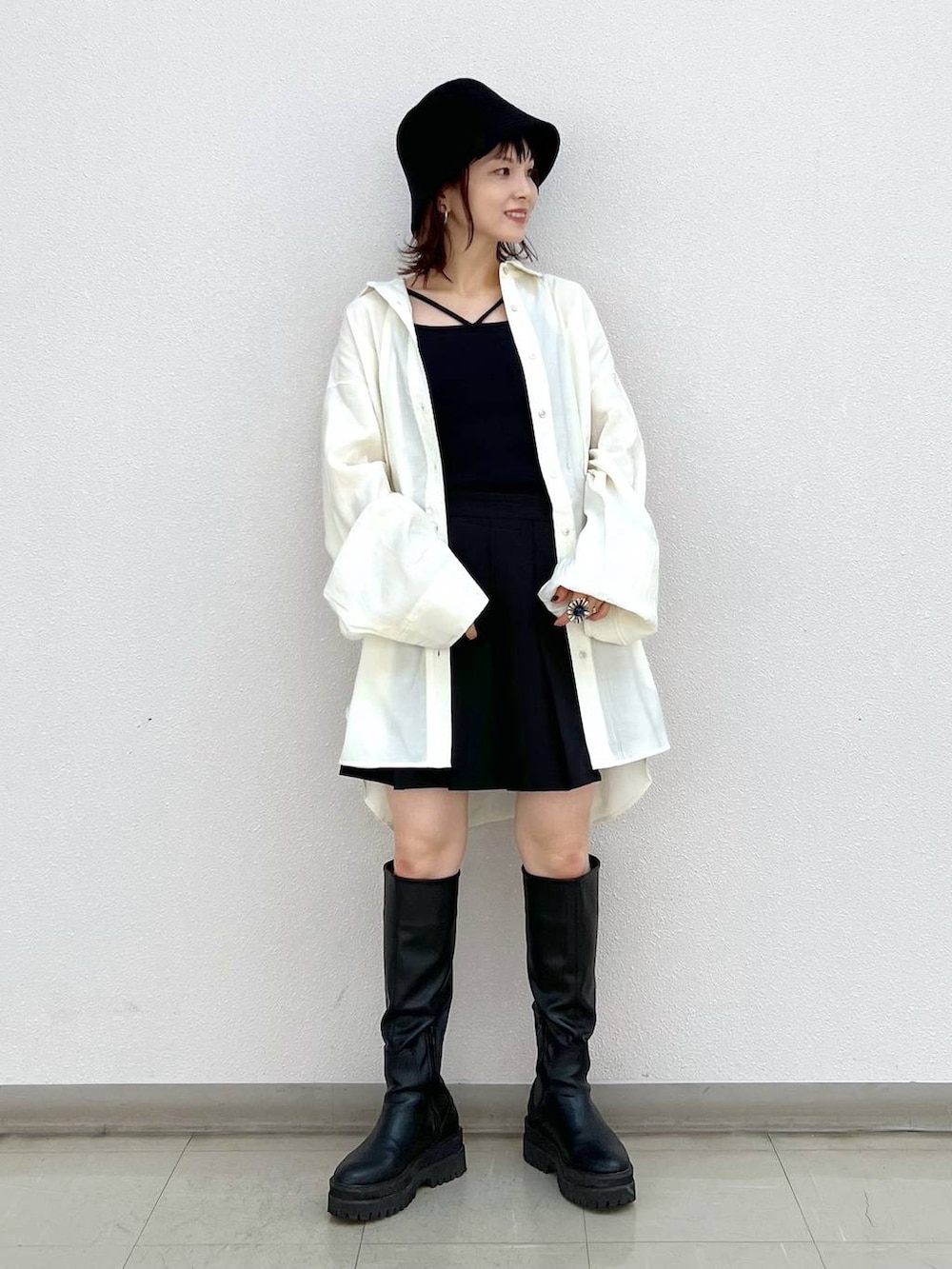 ブラック系のブーツ、ホワイト系のシャツ/ブラウス、ブラック系のスカートを着用したレディースの秋コーディネートの7枚目の写真