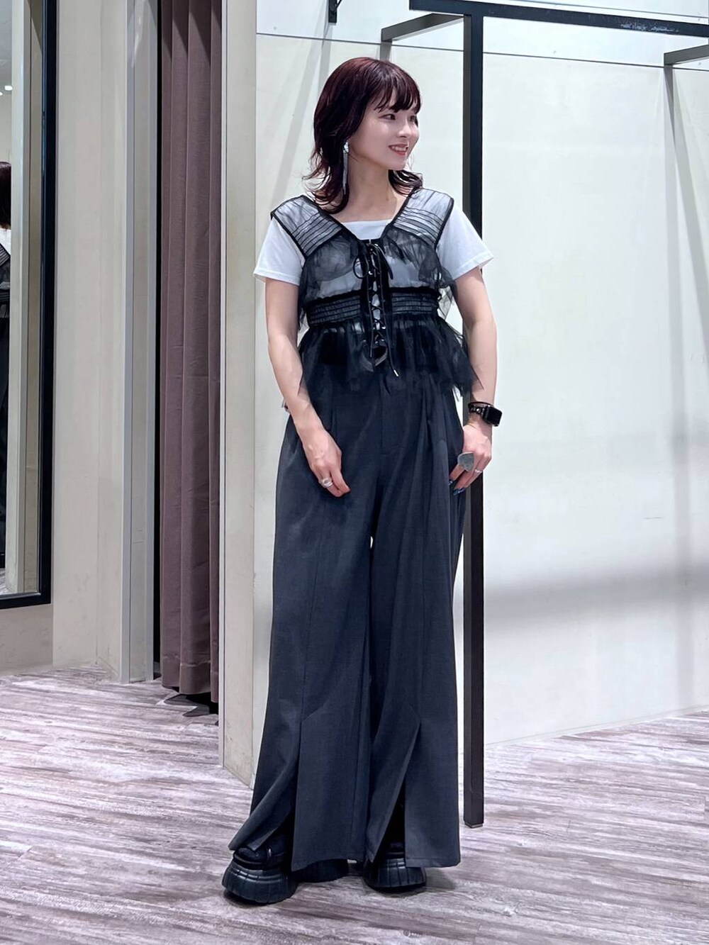 ブラック系のスニーカー、グレー系のスラックス、ブラック系のベストを着用したレディースの夏コーディネートの6枚目の写真