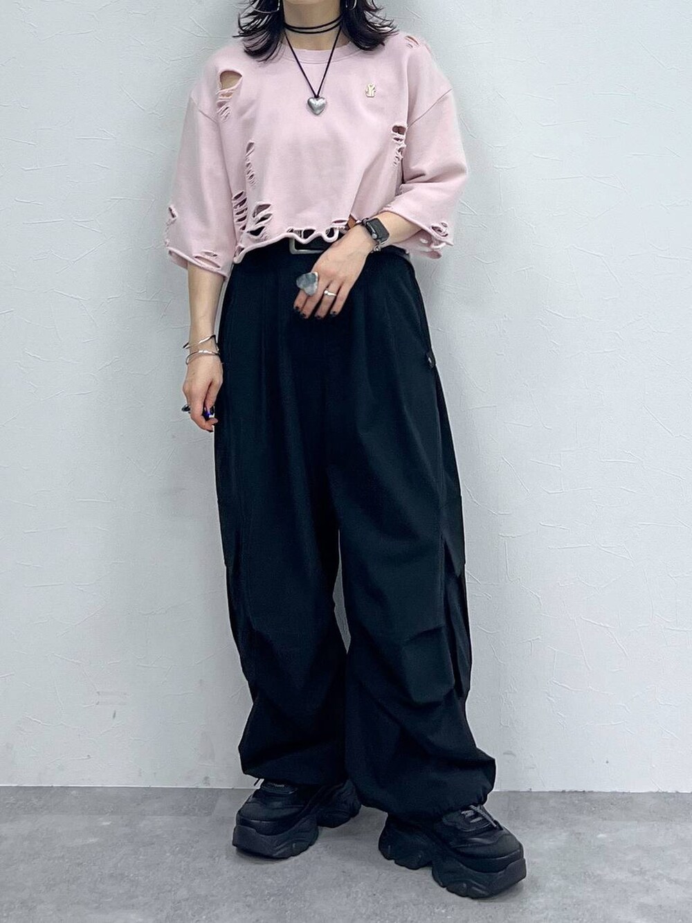 ブラック系のカーゴパンツ、ブラック系のスニーカー、ピンク系のTシャツ/カットソーを着用したレディースの秋コーディネートの5枚目の写真