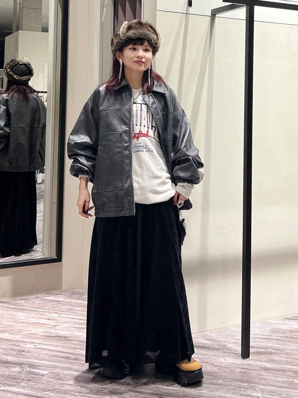 ブラック系のデニムパンツ、ブラウン系のブーツ、グレー系のブルゾンを着用したレディースの秋コーディネートの6枚目の写真