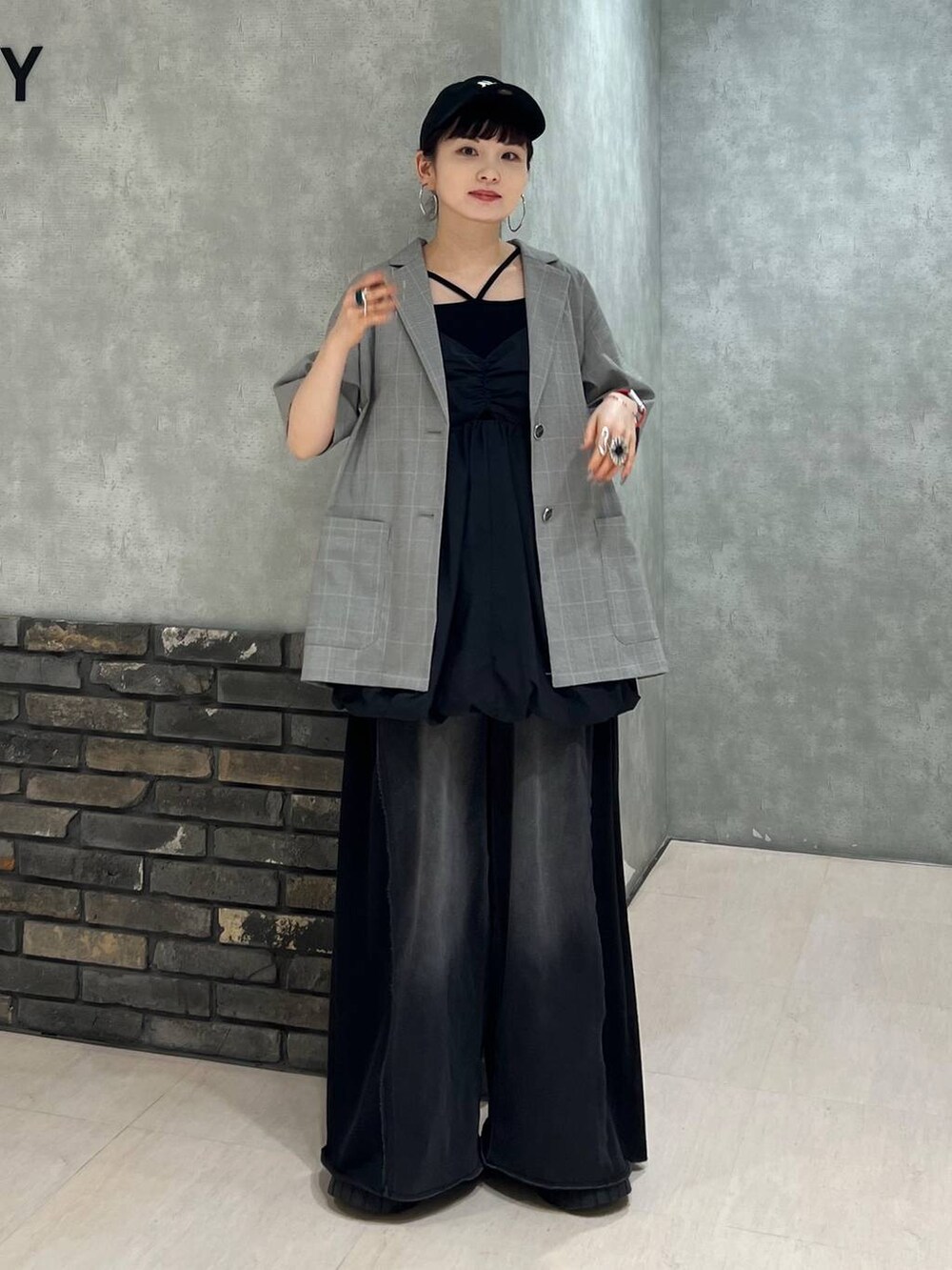 ブラック系のデニムパンツ、ベージュ系のテーラードジャケット、ブラック系のワンピースを着用したレディースの夏コーディネートの7枚目の写真