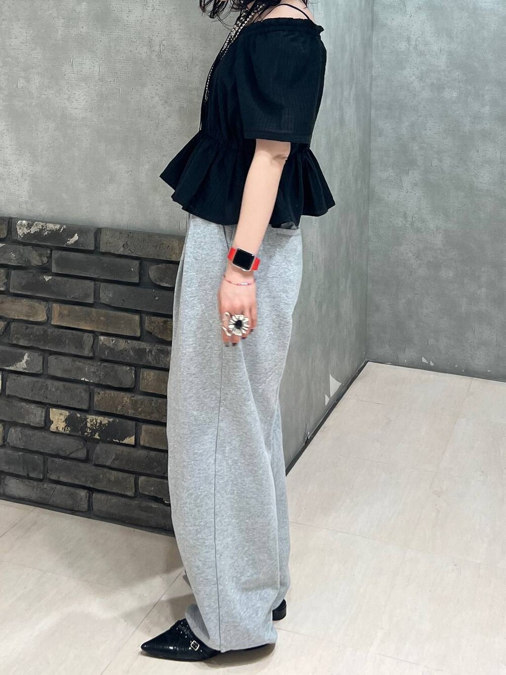 ブラック系のパンプス、ブラック系のシャツ/ブラウス、グレー系のスウェットパンツを着用したレディースの春コーディネートの4枚目の写真