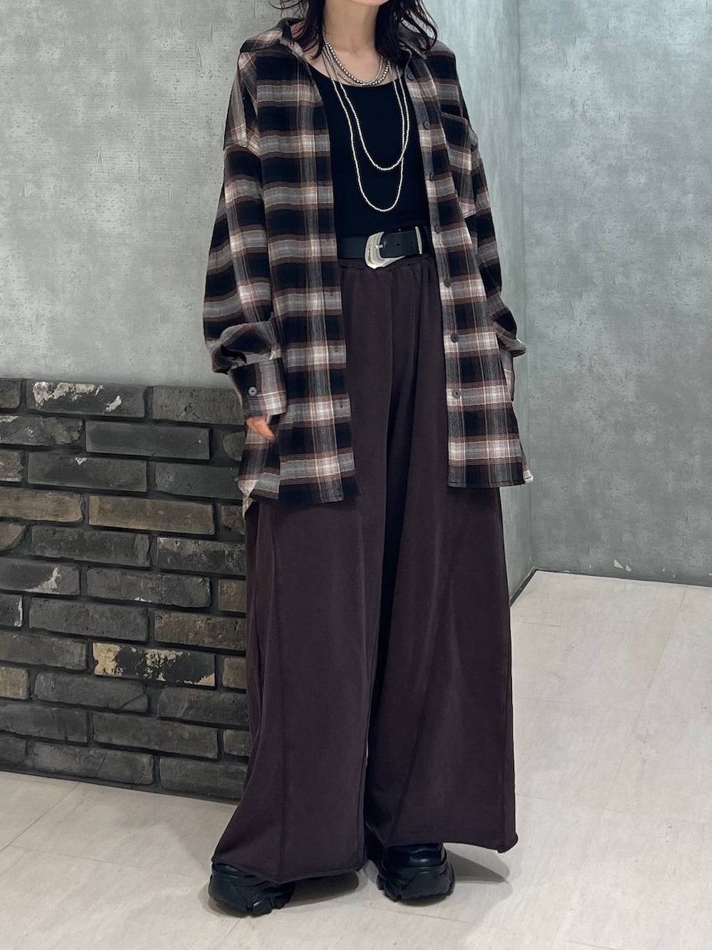 ブラック系のブーツ、ブラウン系のスウェットパンツ、ブラウン系のシャツ/ブラウスを着用したレディースの秋コーディネートの6枚目の写真