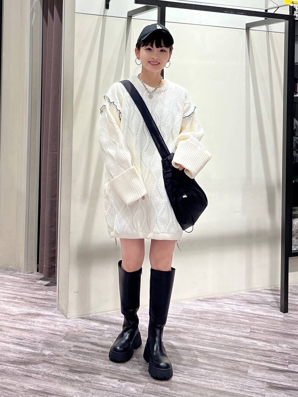 ブラック系のブーツ、ブラック系のショルダーバッグ、ホワイト系のニット/セーターを着用したレディースの冬コーディネートの8枚目の写真