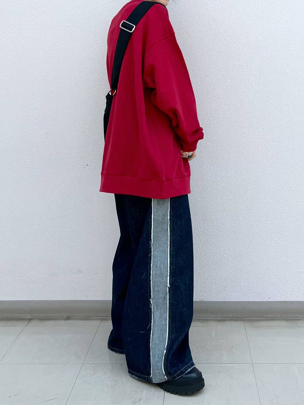 ブラック系のブーツ、ブラック系のショルダーバッグ、レッド系のスウェットを着用したレディースの秋コーディネートの5枚目の写真