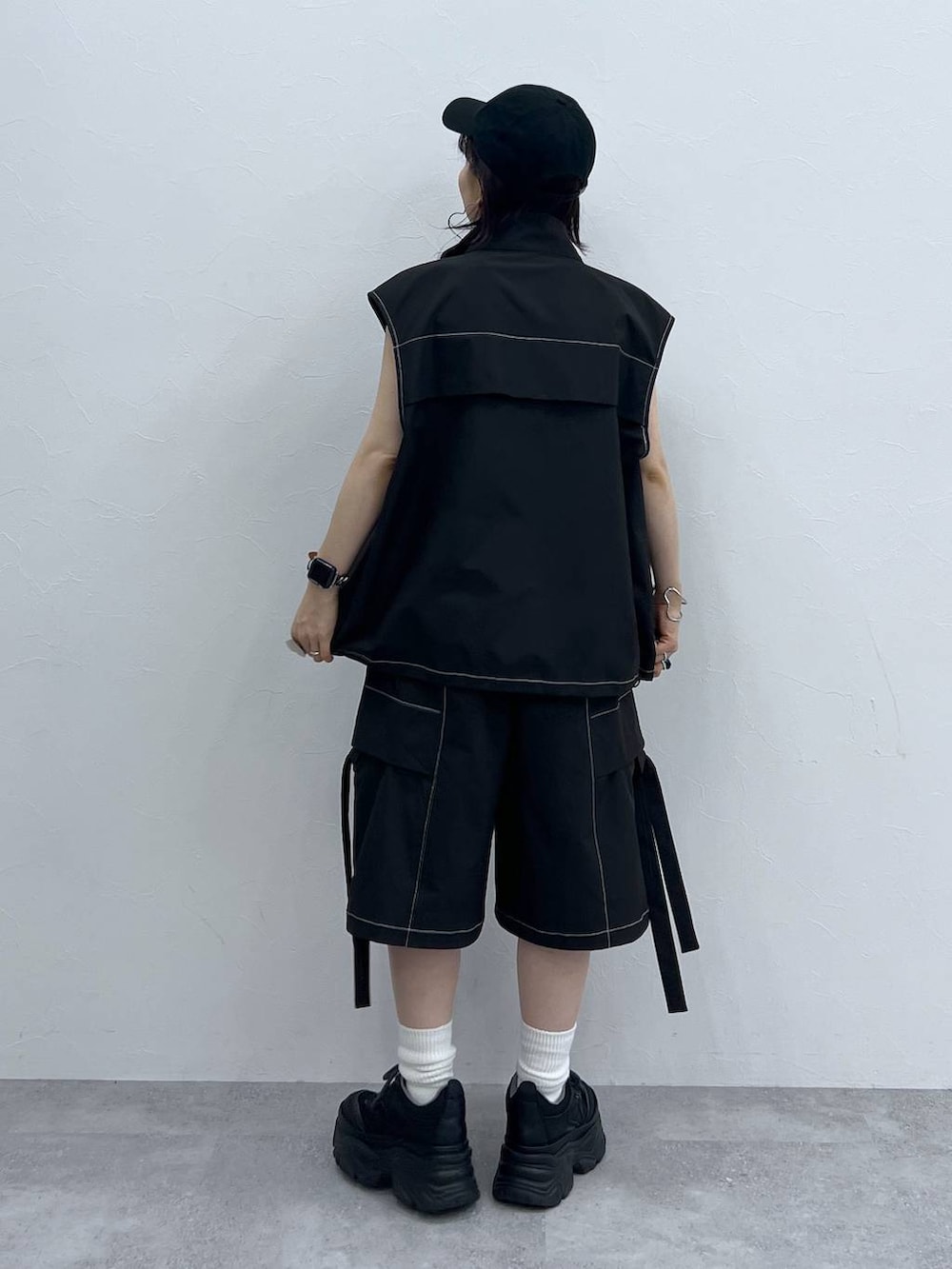 ブラック系のキャミソール、ブラック系のスニーカー、ブラック系のベストを着用したレディースの夏コーディネートの3枚目の写真