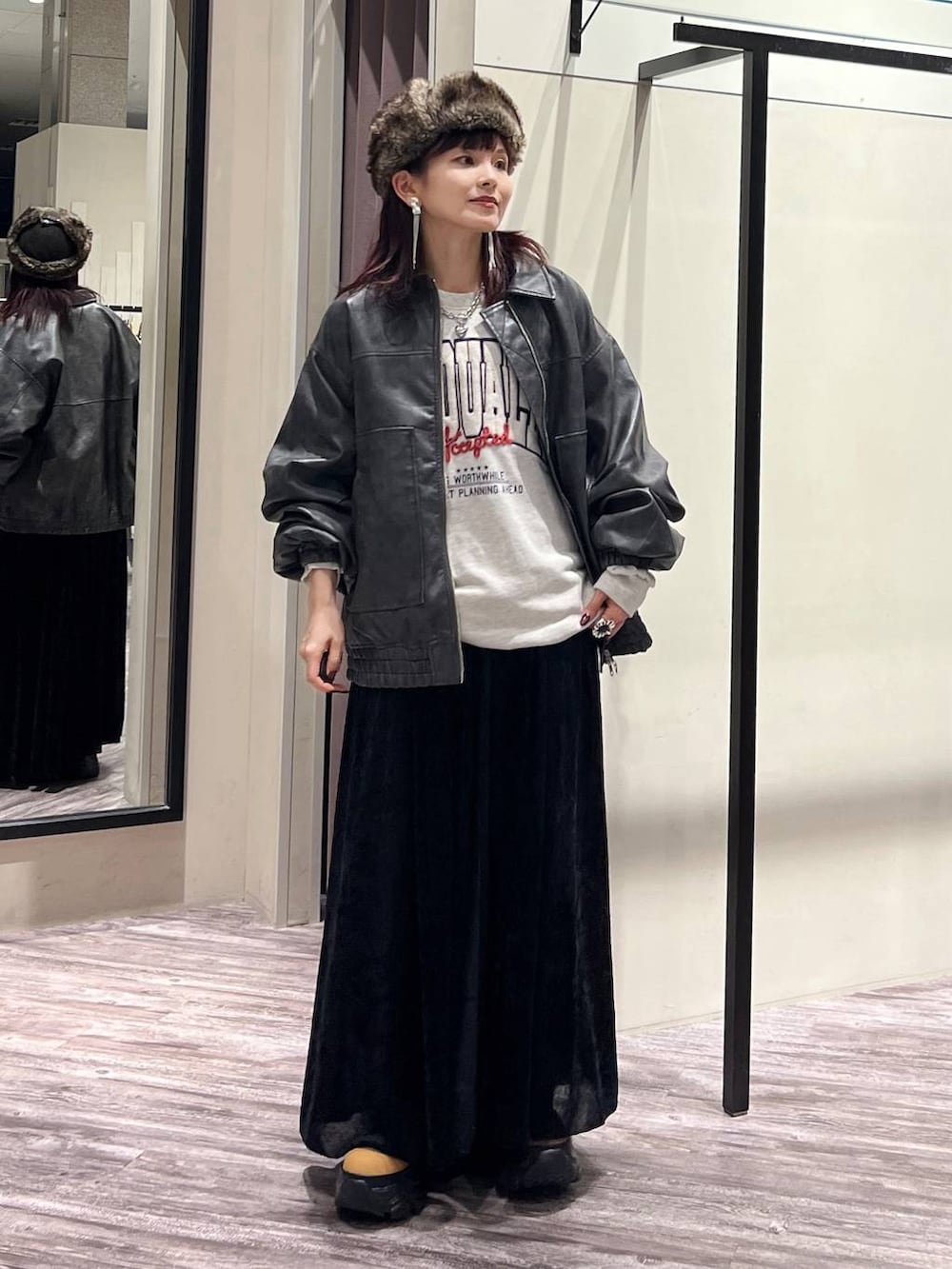 ブラック系のデニムパンツ、ブラウン系のブーツ、グレー系のブルゾンを着用したレディースの秋コーディネートの2枚目の写真