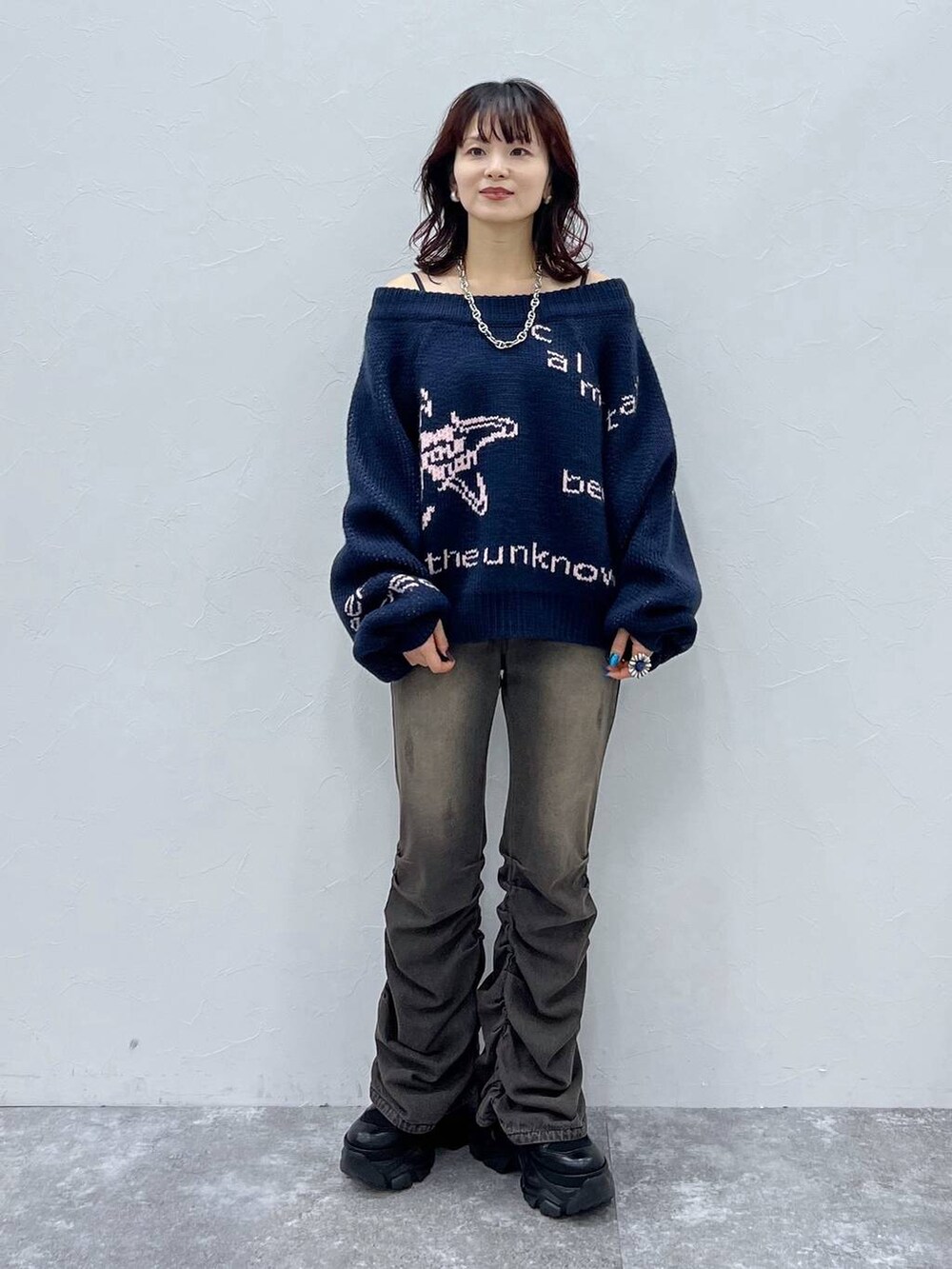 ブラック系のデニムパンツ、ブラック系のブーツ、ブルー系のニット/セーターを着用したレディースの冬コーディネートの6枚目の写真