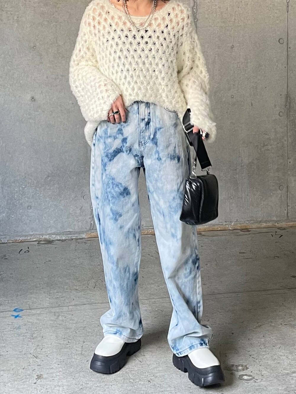 ブルー系のデニムパンツ、ホワイト系のブーツ、ホワイト系のニット/セーターを着用したレディースの秋コーディネートの7枚目の写真