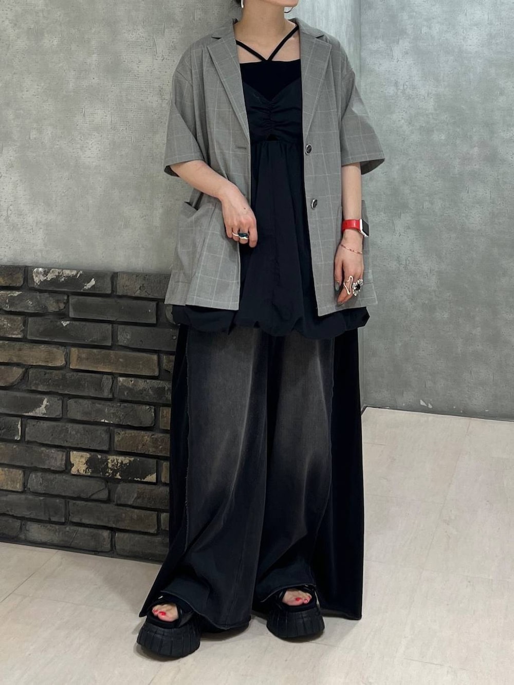 ブラック系のデニムパンツ、ベージュ系のテーラードジャケット、ブラック系のワンピースを着用したレディースの夏コーディネートの6枚目の写真