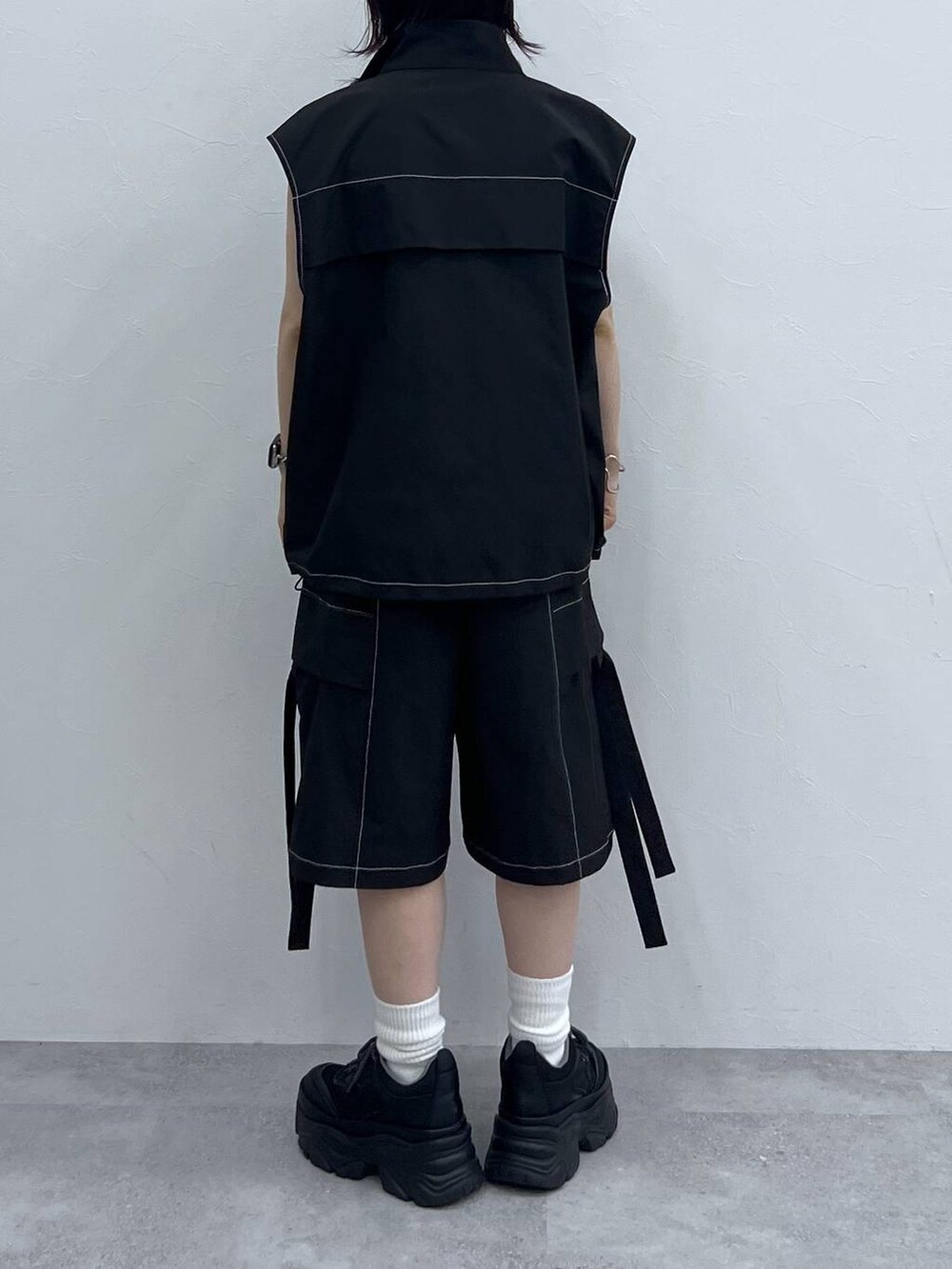 ブラック系のキャミソール、ブラック系のスニーカー、ブラック系のベストを着用したレディースの夏コーディネートの4枚目の写真