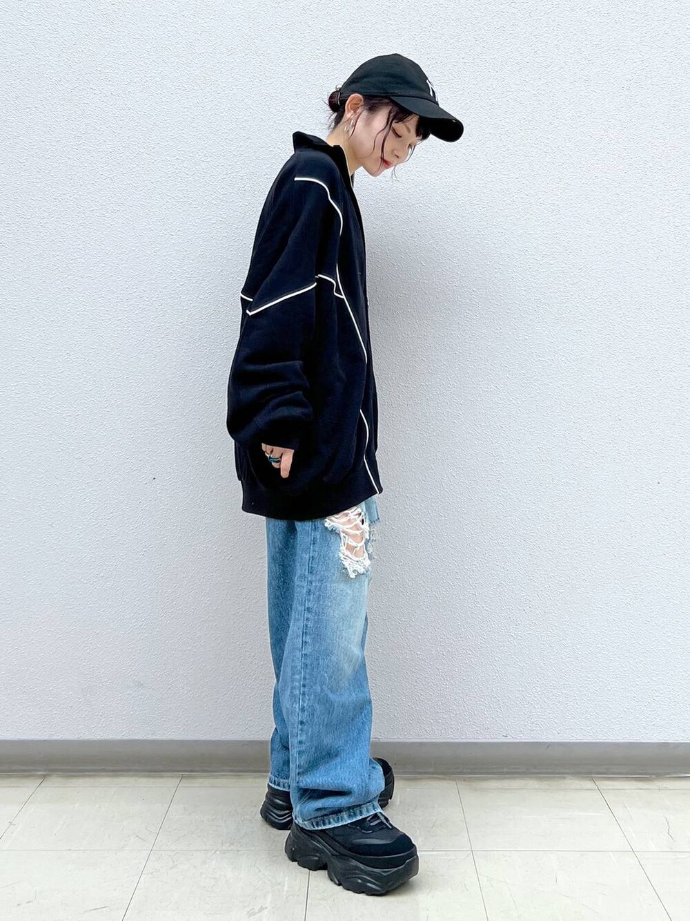 ブラック系のキャミソール、ブルー系のデニムパンツ、ブラック系のスニーカーを着用したレディースの春コーディネートの4枚目の写真