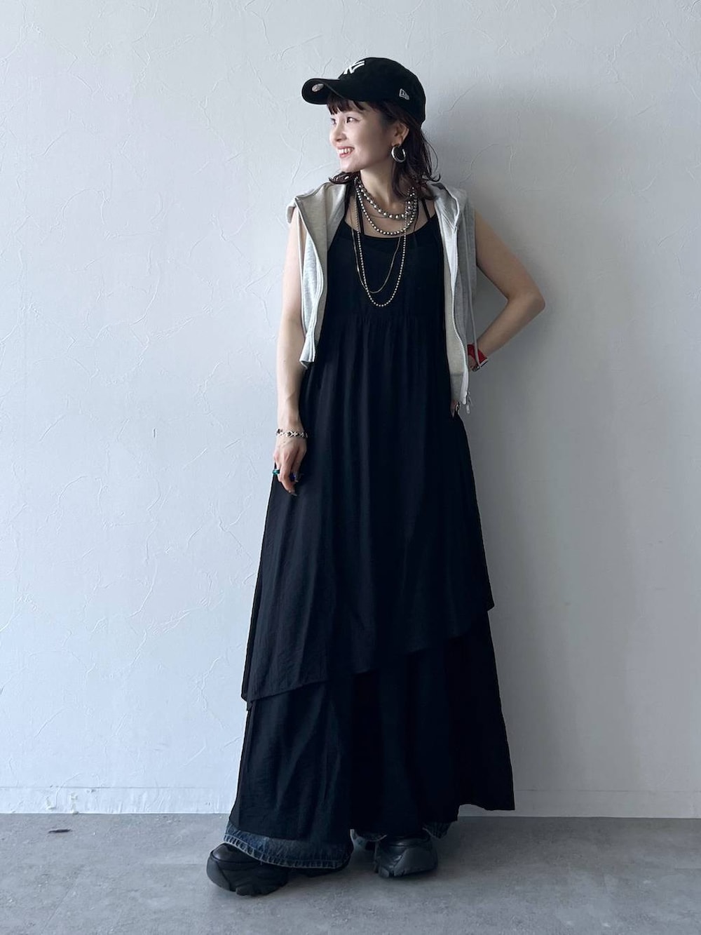 ブラック系のスニーカー、ブルー系のデニムパンツ、ブラック系のキャミソールを着用したレディースの夏コーディネートの2枚目の写真