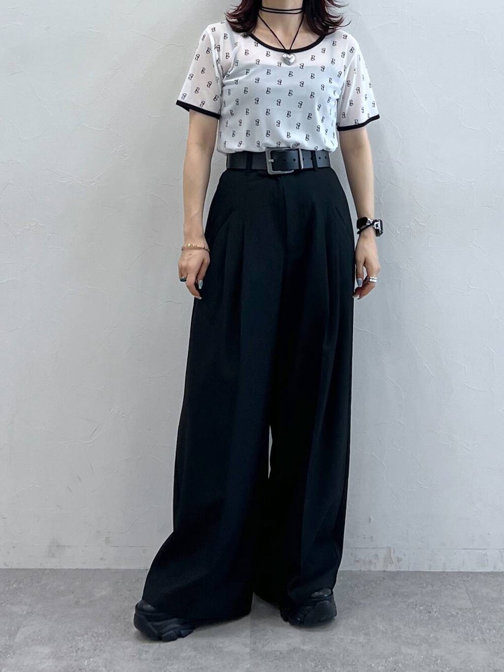 ブラック系のスニーカー、ホワイト系のTシャツ/カットソー、ブラック系のスラックスを着用したレディースの夏コーディネートの4枚目の写真
