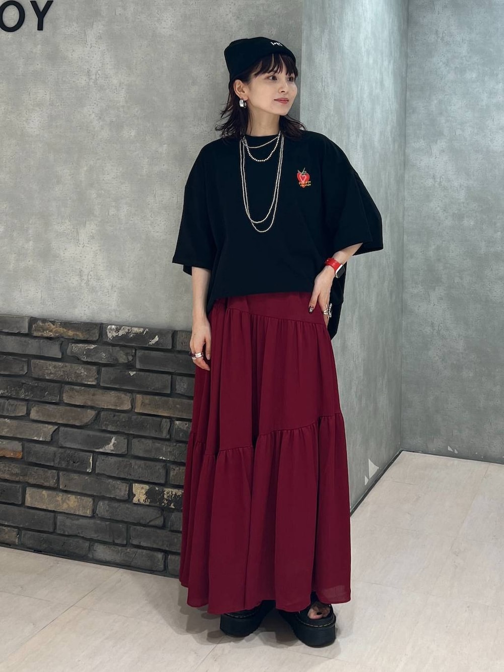 ブラック系のTシャツ/カットソー、レッド系のスカート、ブラック系のニットキャップ/ビーニーを着用したレディースの夏コーディネートの7枚目の写真