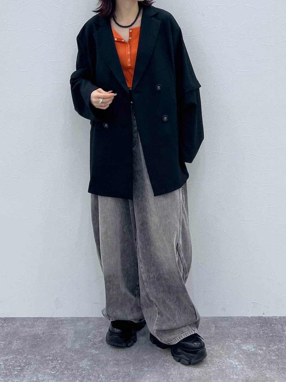 ブラック系のブーツ、ブラック系のテーラードジャケット、ブラック系のデニムパンツを着用したレディースの春コーディネートの6枚目の写真