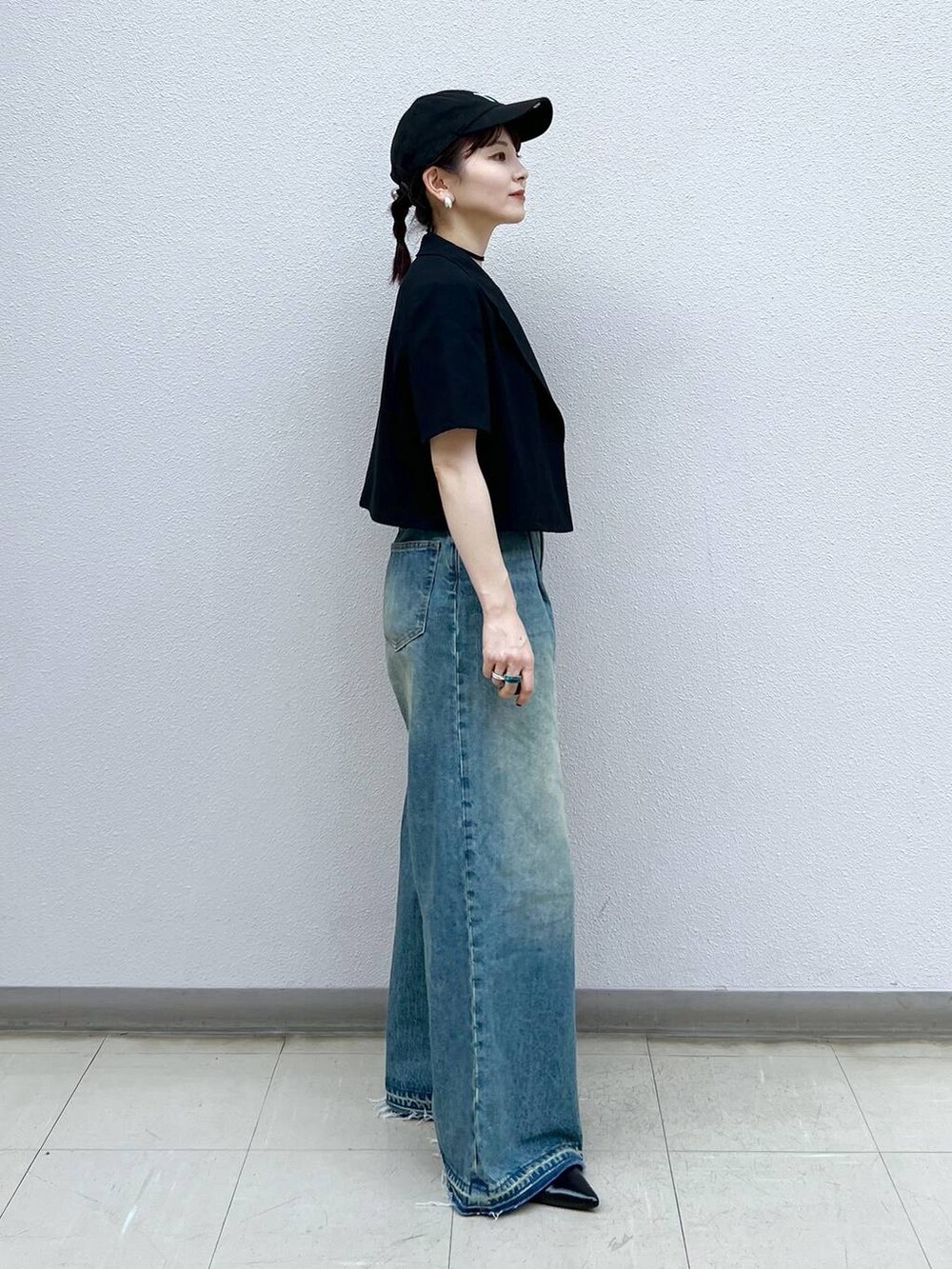 ブルー系のデニムパンツ、ブラック系のパンプス、ブラック系のチョーカーを着用したレディースの夏コーディネートの3枚目の写真