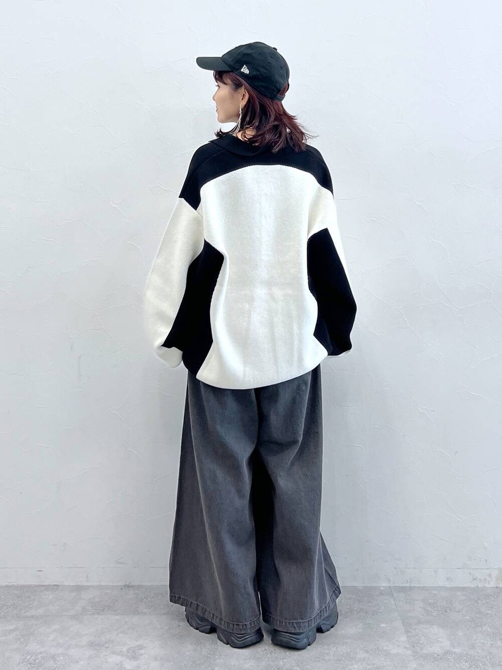 ブラック系のデニムパンツ、ブラック系のニット/セーター、ブラック系のスニーカーを着用したレディースの秋コーディネートの5枚目の写真