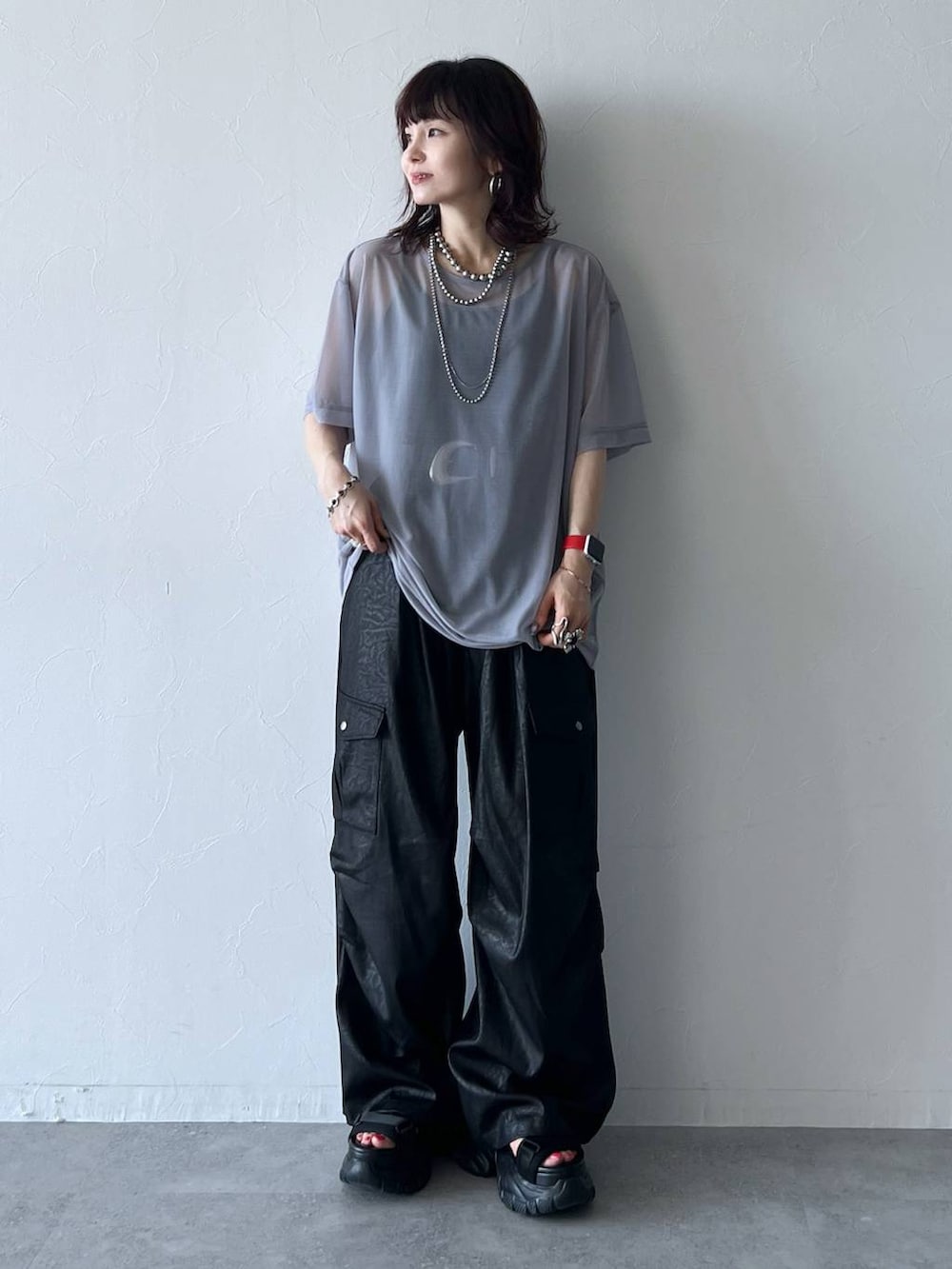 ブラック系のサンダル、ブラック系のキャミソール、ブラック系のカーゴパンツを着用したレディースの夏コーディネートの2枚目の写真