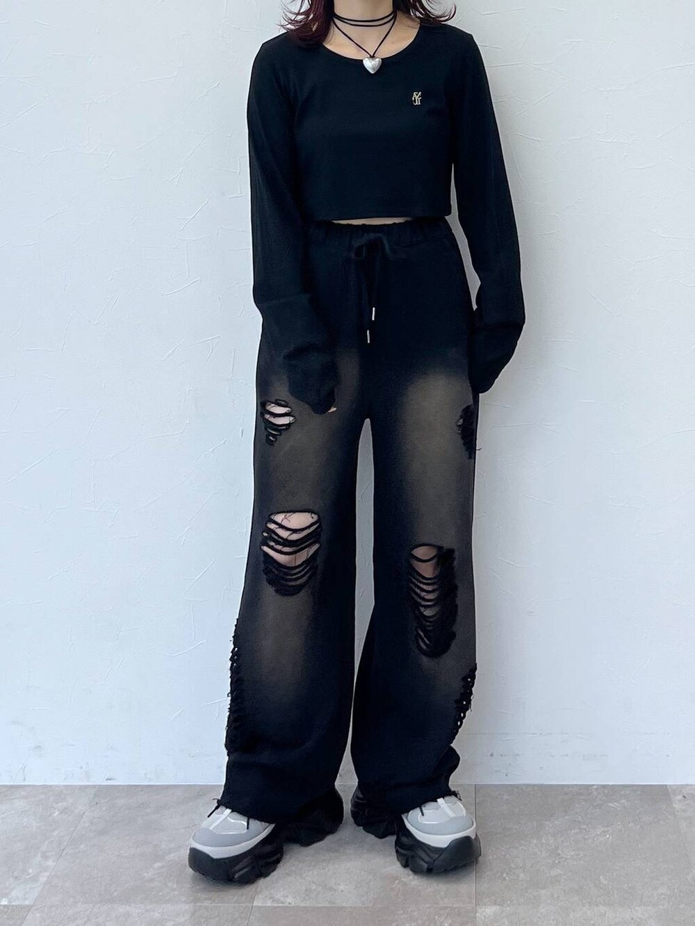 グレー系のスニーカー、ブラック系のスウェットパンツ、ブラック系のTシャツ/カットソーを着用したレディースの秋コーディネートの5枚目の写真