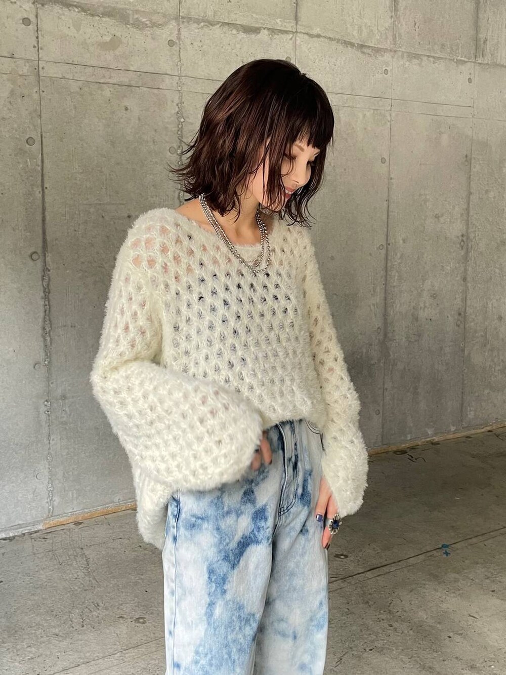 ブルー系のデニムパンツ、ホワイト系のブーツ、ホワイト系のニット/セーターを着用したレディースの秋コーディネートの9枚目の写真