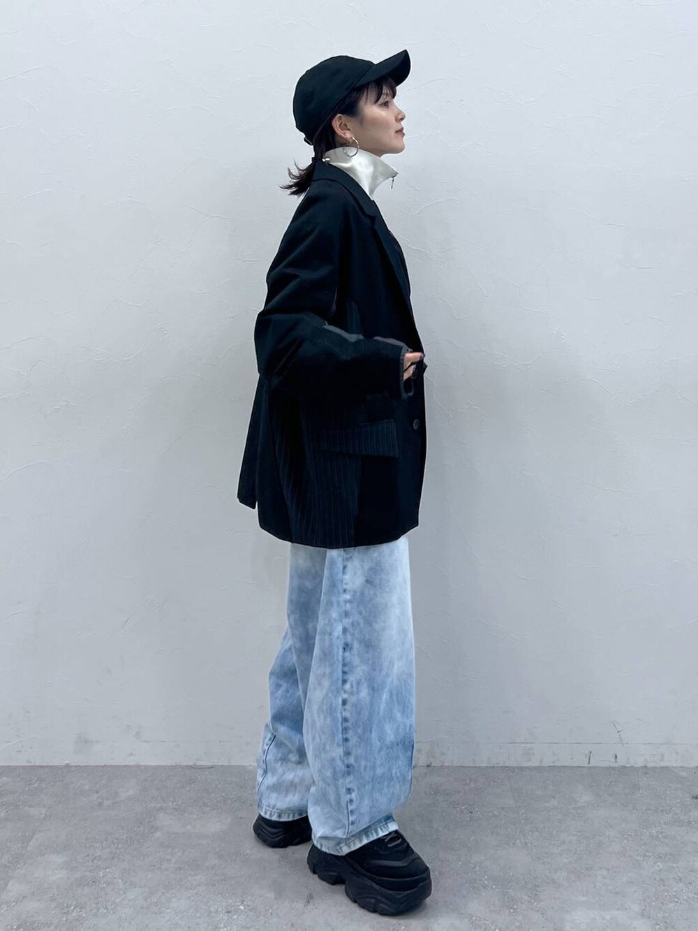 ブラック系のテーラードジャケット、ブラック系のスニーカー、ブラック系のジャージを着用したレディースの春コーディネートの3枚目の写真