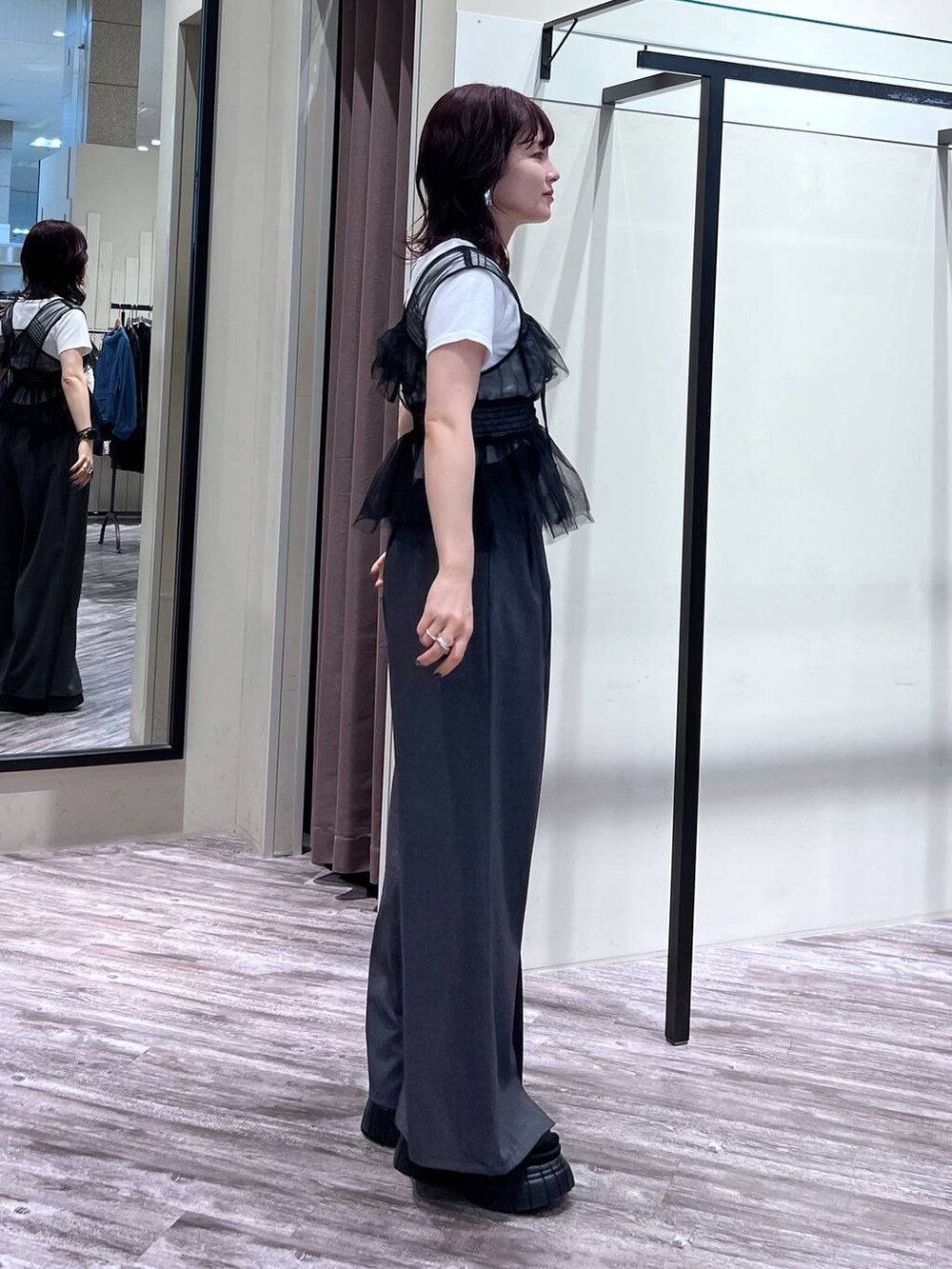 ブラック系のスニーカー、グレー系のスラックス、ブラック系のベストを着用したレディースの夏コーディネートの4枚目の写真