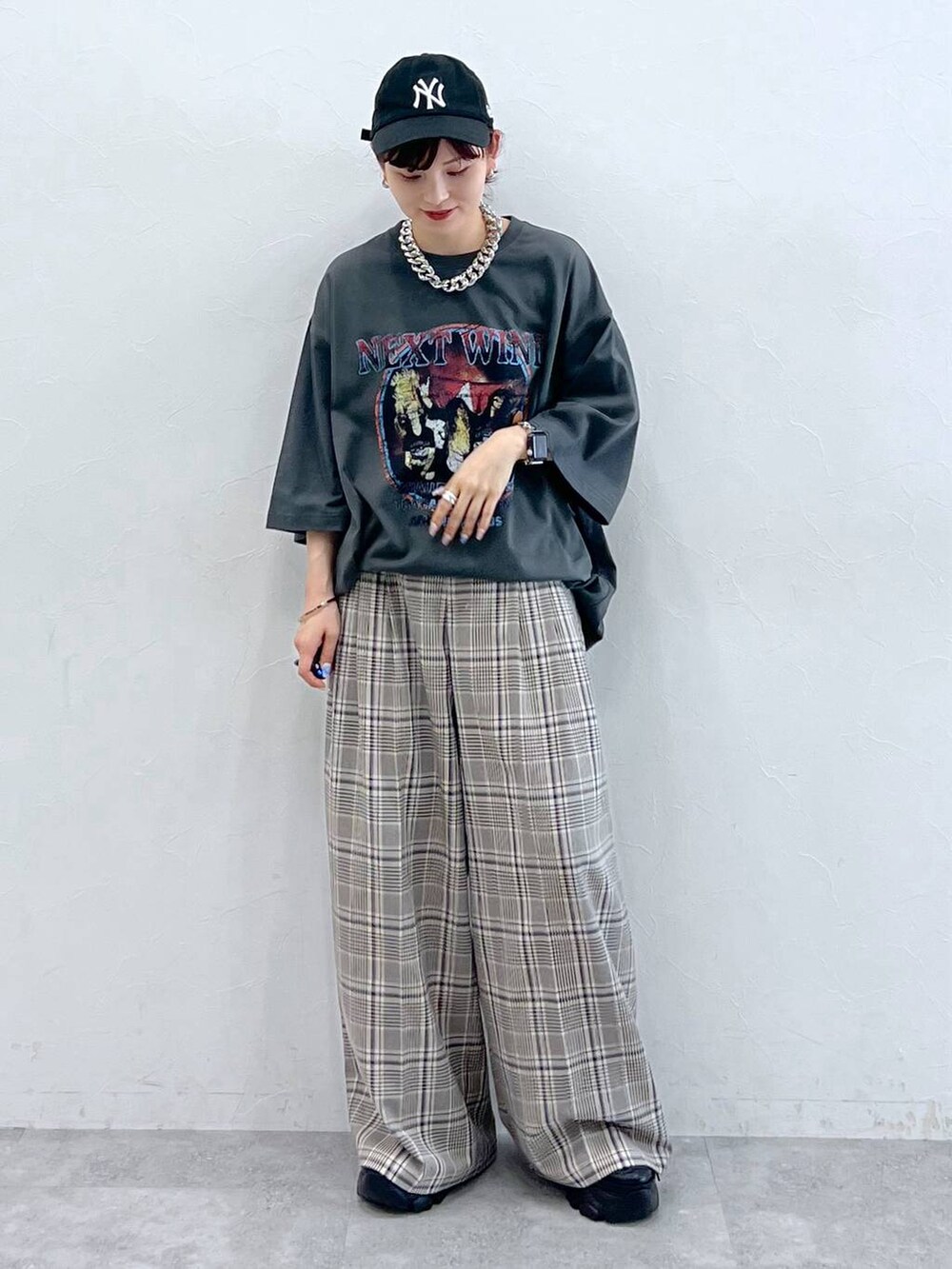 ブラック系のスニーカー、グレー系のTシャツ/カットソー、ベージュ系のスラックスを着用したレディースの秋コーディネートの2枚目の写真