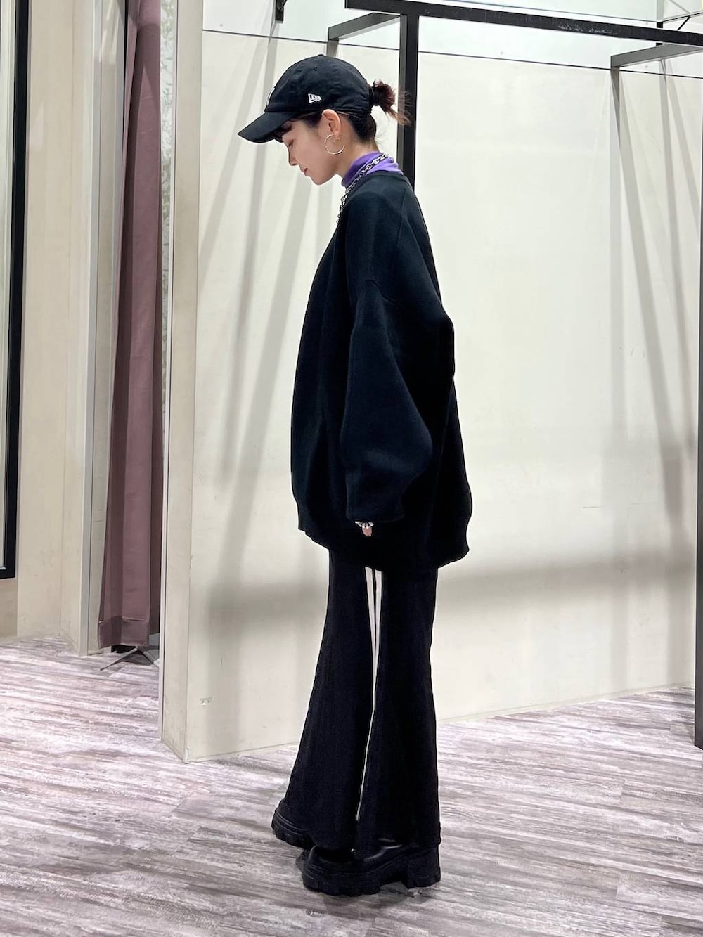 ブラック系のニット/セーター、パープル系のTシャツ/カットソー、ブラック系のスニーカーを着用したレディースの冬コーディネートの4枚目の写真