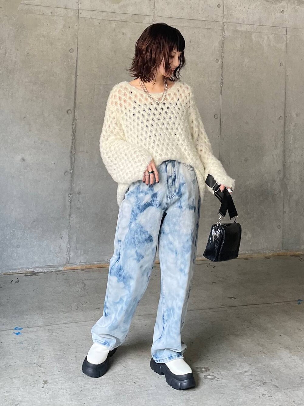 ブルー系のデニムパンツ、ホワイト系のブーツ、ホワイト系のニット/セーターを着用したレディースの秋コーディネートの2枚目の写真