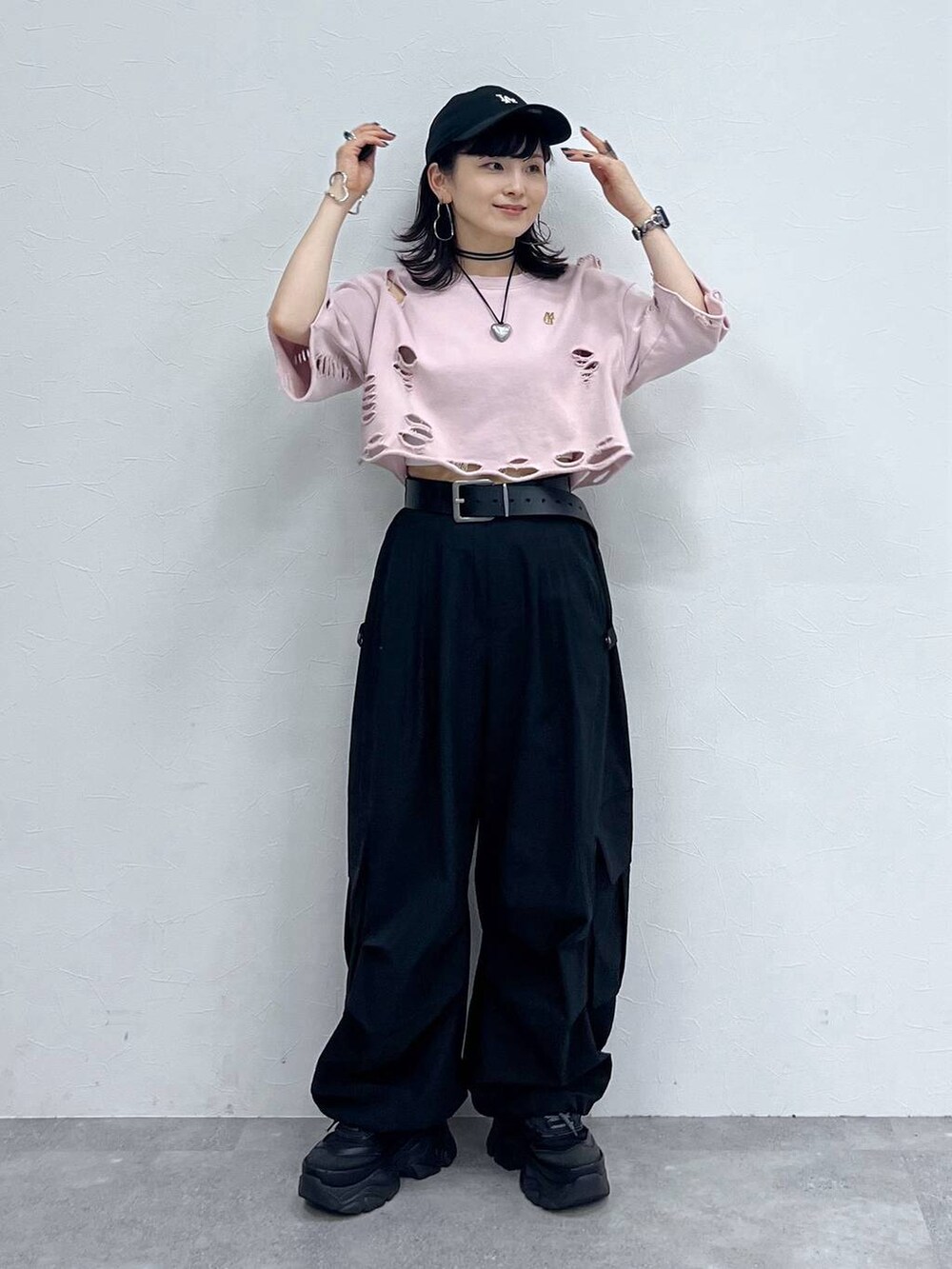 ブラック系のカーゴパンツ、ブラック系のスニーカー、ピンク系のTシャツ/カットソーを着用したレディースの秋コーディネートの2枚目の写真