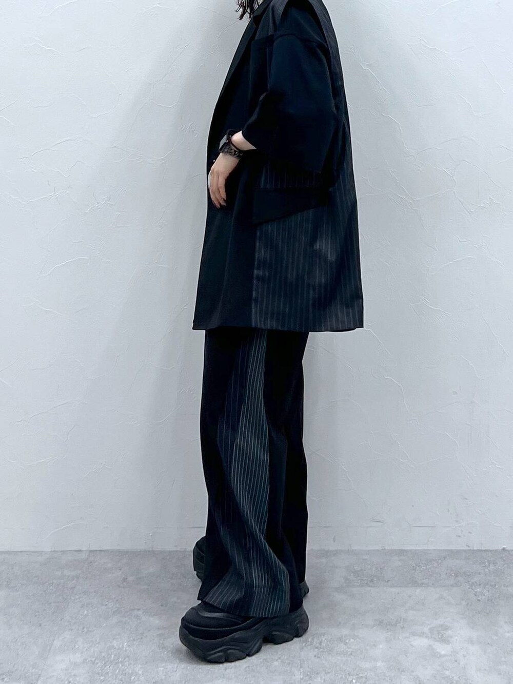 ブラック系のスラックス、ブラック系のTシャツ/カットソー、ブラック系のスニーカーを着用したレディースの春コーディネートの5枚目の写真