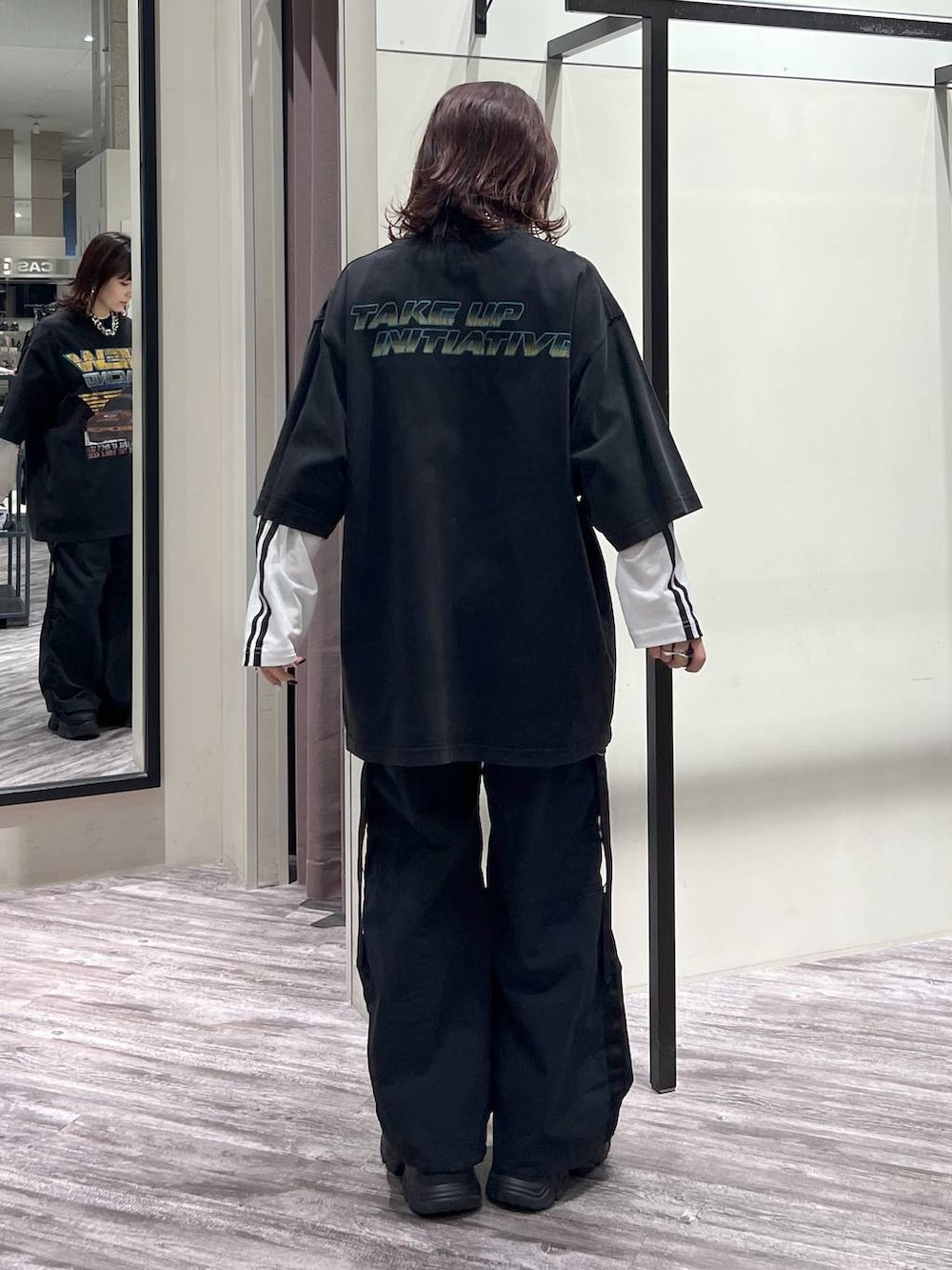 ブラック系のスニーカー、ブラック系のカーゴパンツ、ブラック系のTシャツ/カットソーを着用したレディースの春コーディネートの4枚目の写真