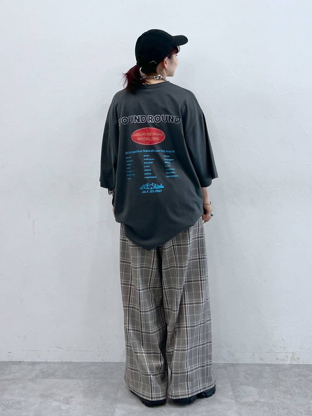 ブラック系のスニーカー、グレー系のTシャツ/カットソー、ベージュ系のスラックスを着用したレディースの秋コーディネートの3枚目の写真