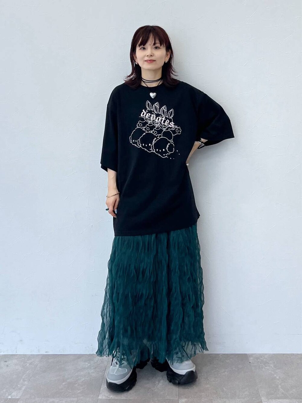 グレー系のスニーカー、グリーン系のスカート、ブラック系のチョーカーを着用したレディースの夏コーディネートの2枚目の写真