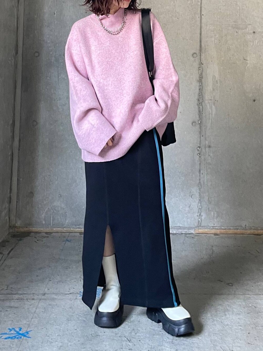 ホワイト系のブーツ、レッド系のニット/セーター、ブラック系のスカートを着用したレディースの秋コーディネートの3枚目の写真