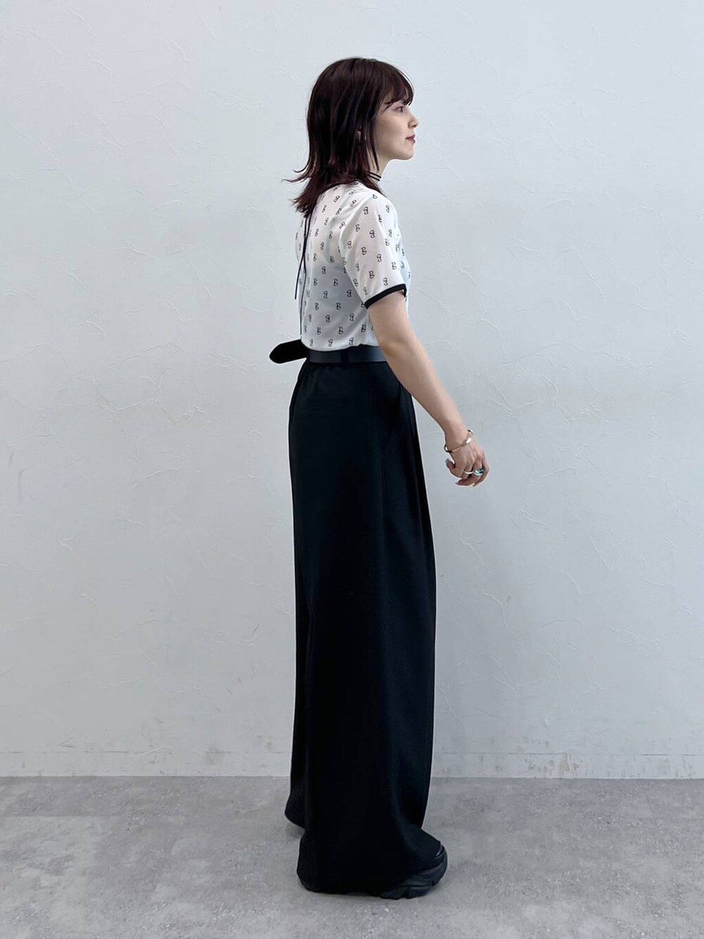 ブラック系のスニーカー、ホワイト系のTシャツ/カットソー、ブラック系のスラックスを着用したレディースの夏コーディネートの3枚目の写真