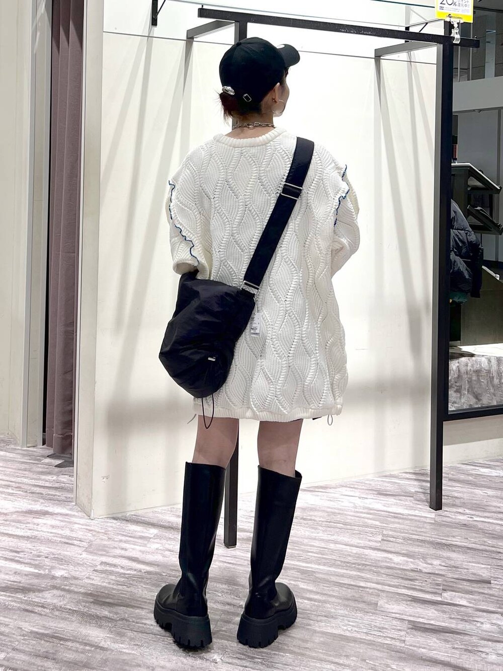 ブラック系のブーツ、ブラック系のショルダーバッグ、ホワイト系のニット/セーターを着用したレディースの冬コーディネートの3枚目の写真